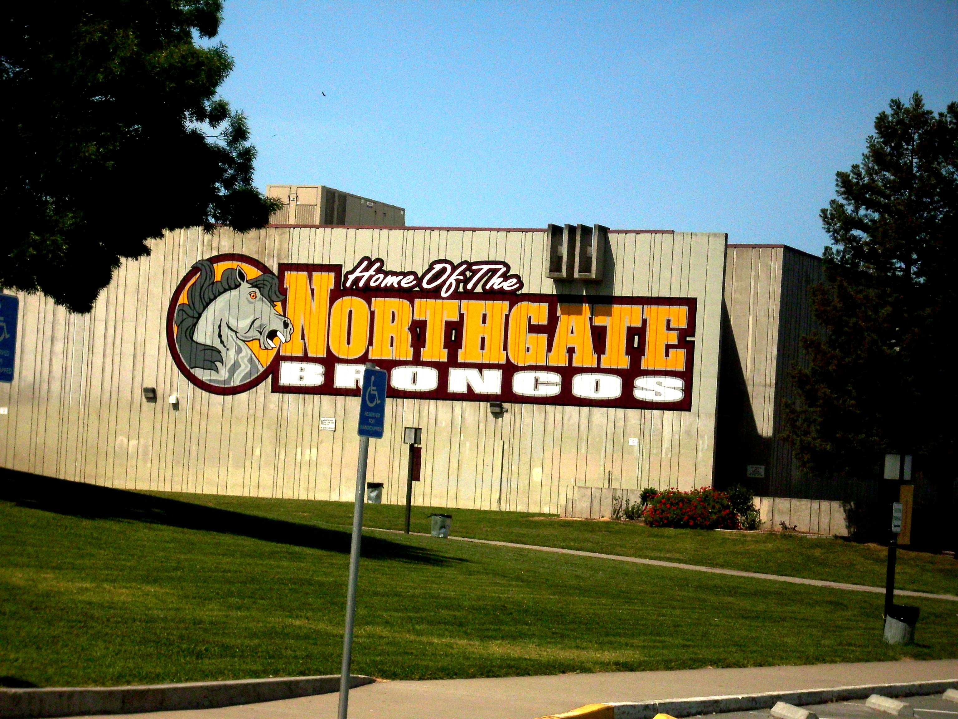 Large 'Home of the Northgate Broncos' mural painted on a school gymnasium exterior wall.