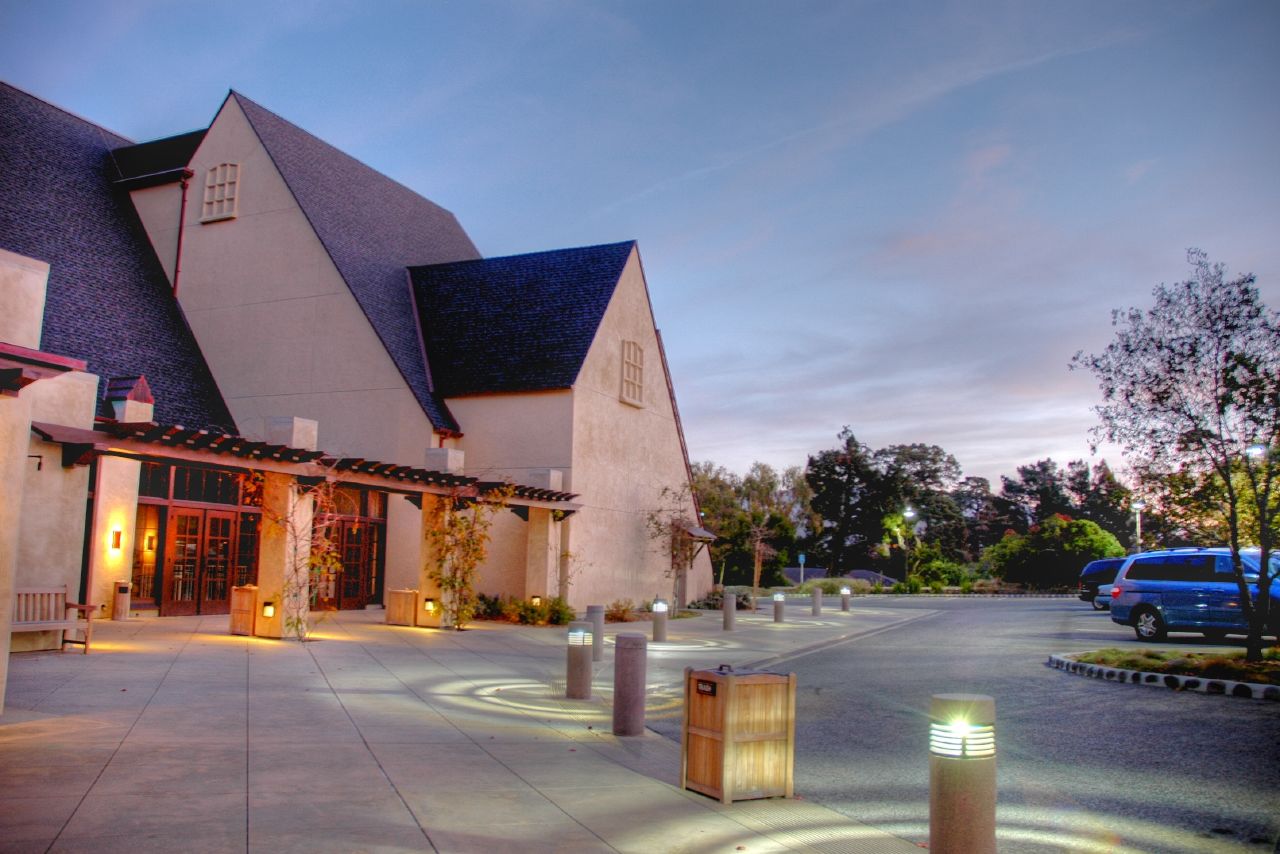 Exterior of Sunset Center building illuminated at dusk with bollard lights along a walkway.