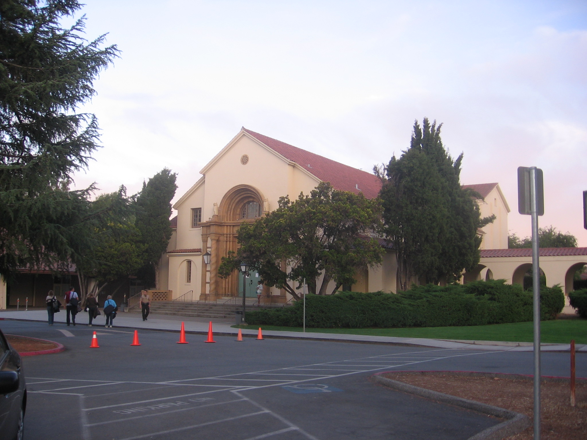 Exterior of a large school building with a red tile roof and arched entrance.