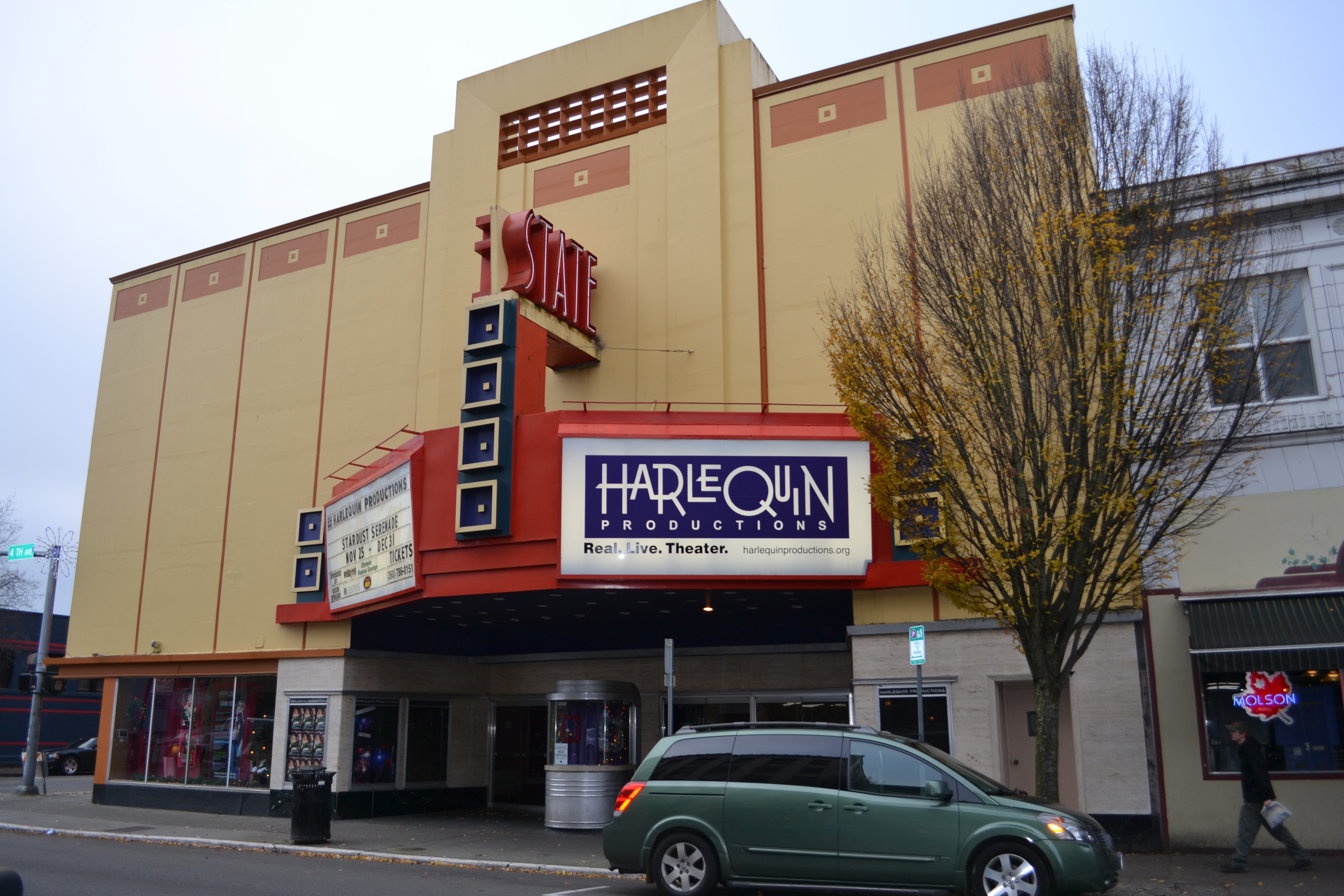 Exterior of the State Theater with a Harlequin Productions banner on the marquee.