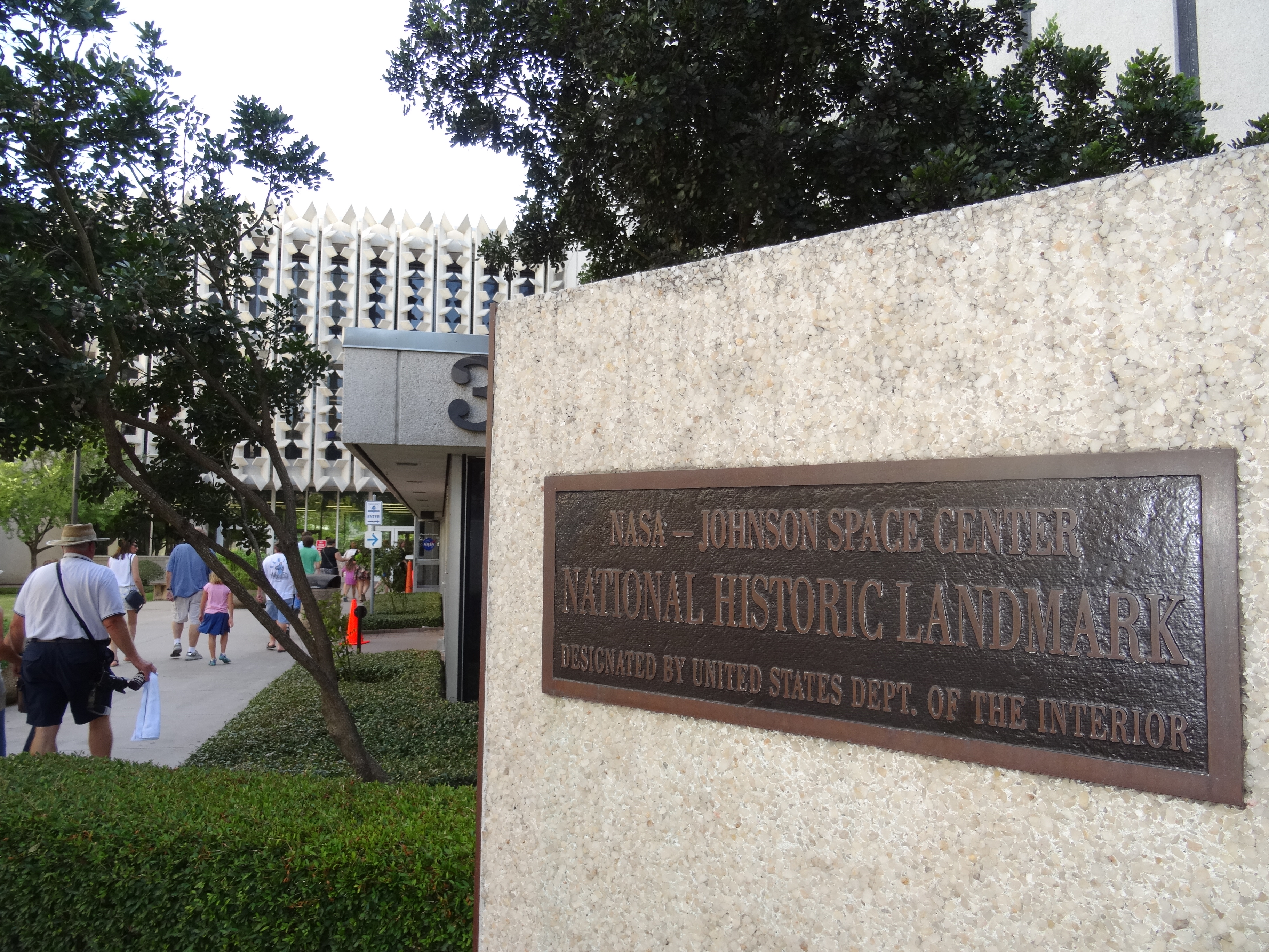 Bronze NASA Johnson Space Center National Historic Landmark plaque mounted on a stone wall.