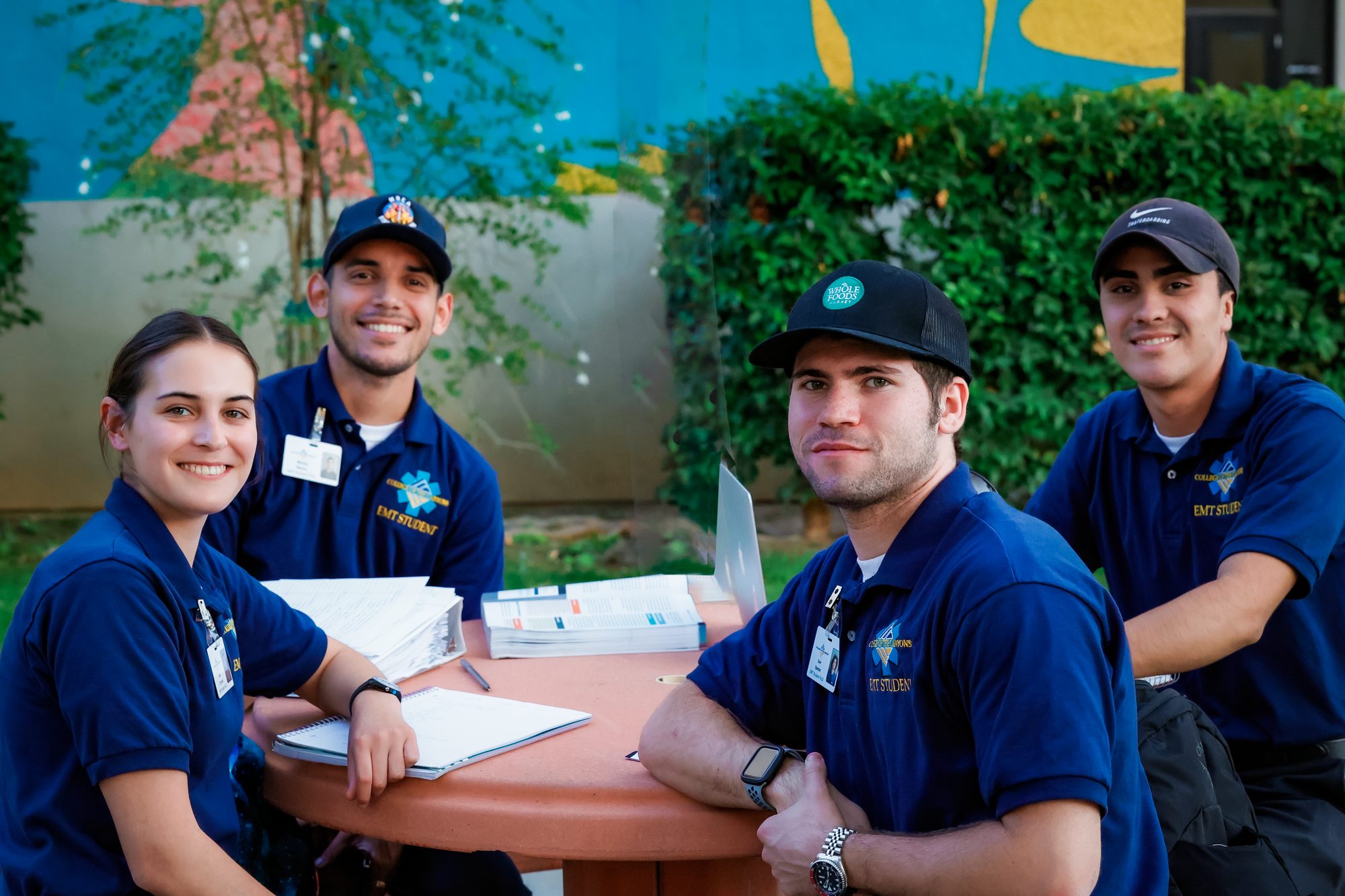 Group of university students in blue uniforms studying and posing together outside.