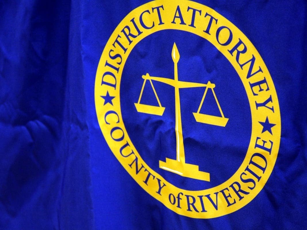 Blue flag bearing the gold seal of the District Attorney, County of Riverside, with scales of justice.