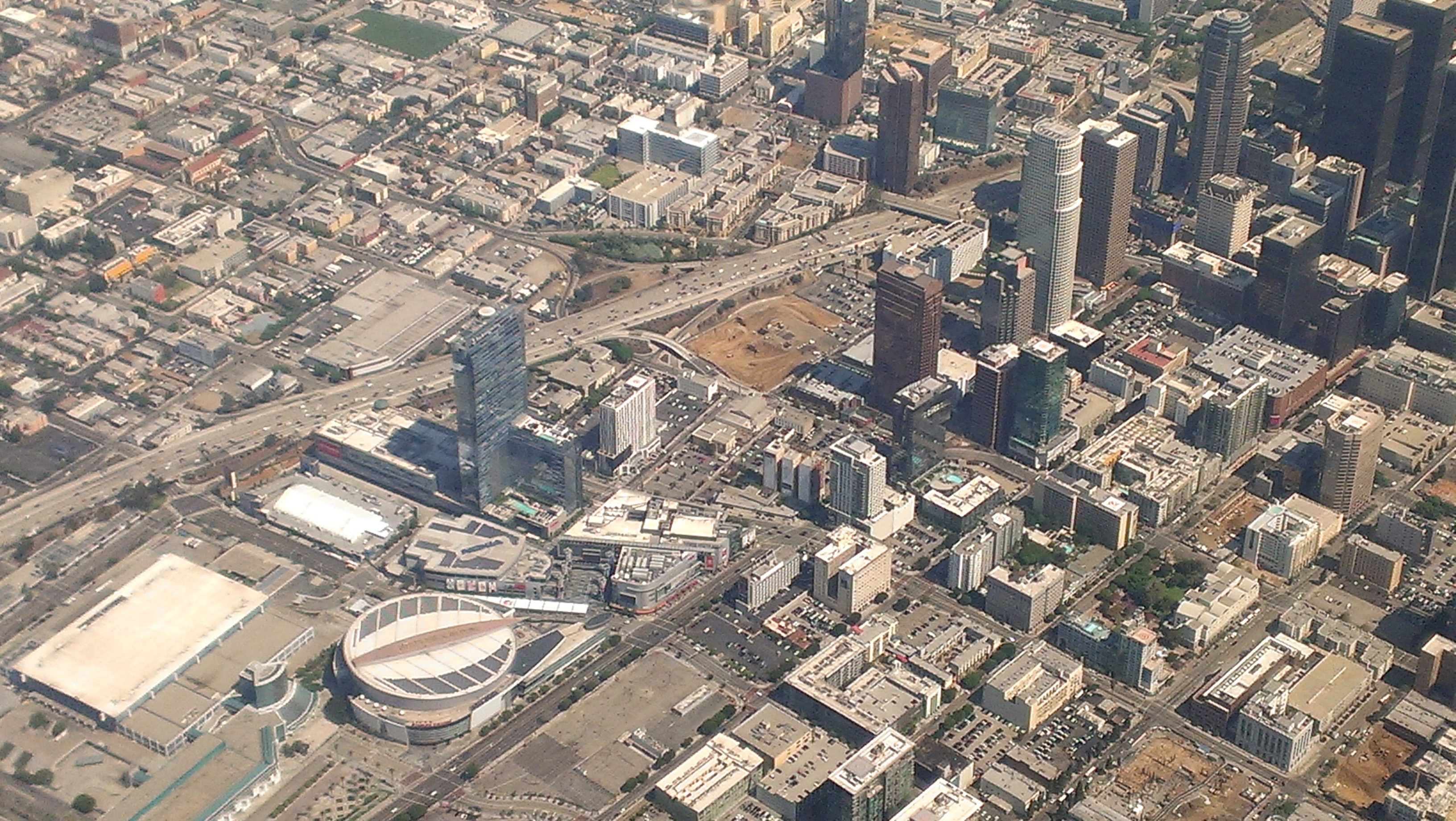Aerial view of downtown Los Angeles with arena and entertainment complex visible.