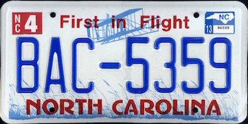 White North Carolina First in Flight license plate with blue and red lettering.