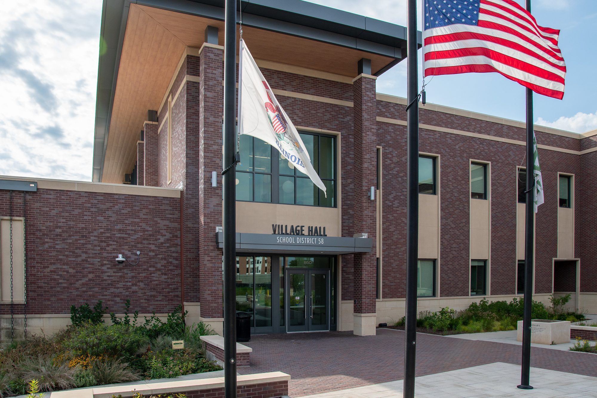 Brick village hall building entrance with American and Illinois state flags