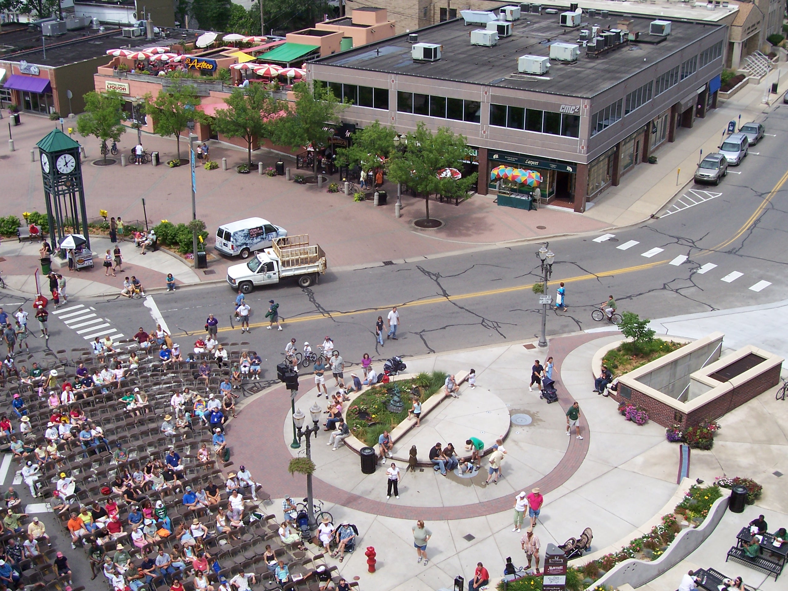 Aerial view of a large crowd gathered at an outdoor downtown festival plaza.