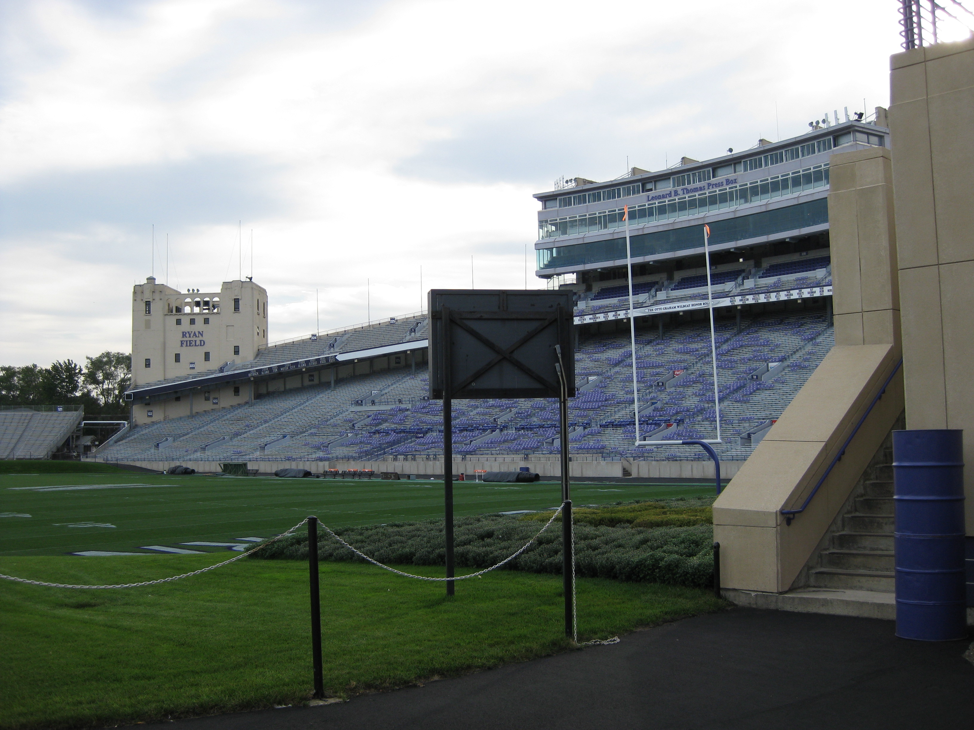Empty college football stadium with purple seats, green field, and Ryan Field signage on a tower.
