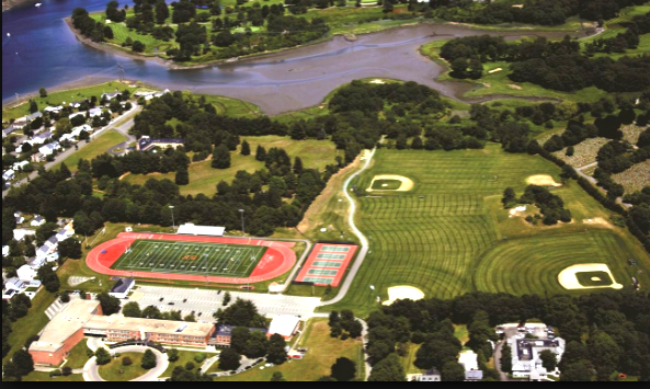 Aerial view of a high school campus with a red running track surrounding a football field.