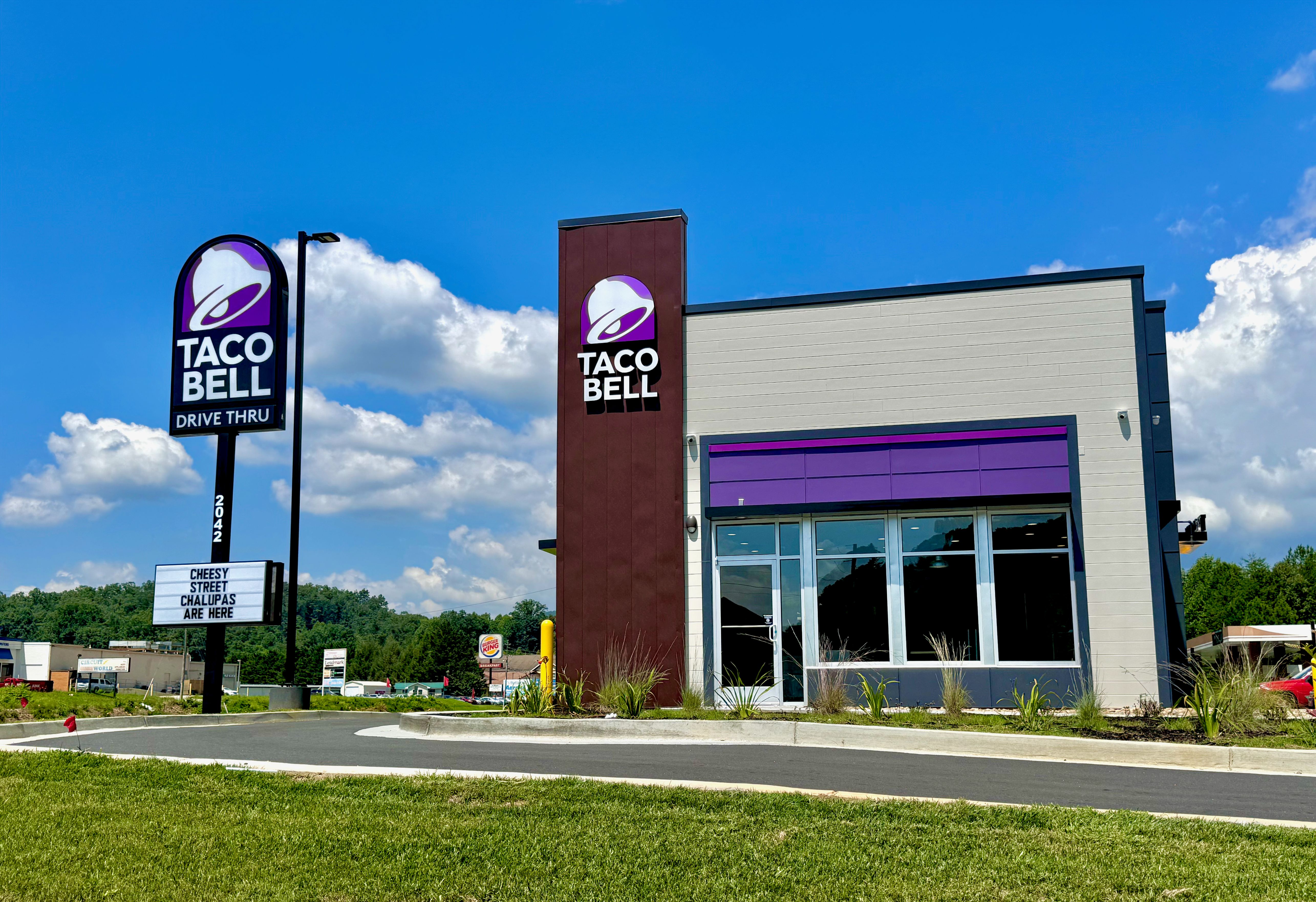 Modern Taco Bell restaurant exterior with purple signage and large glass windows.