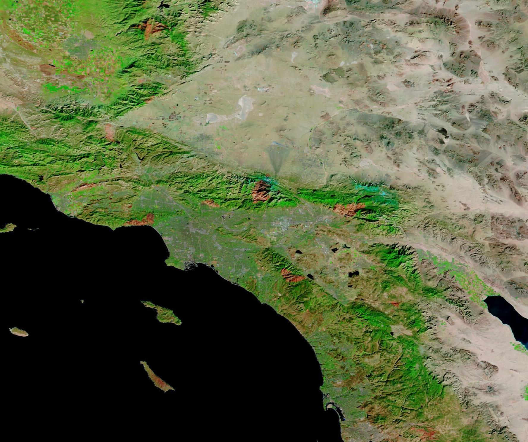False-color satellite image showing large reddish-brown wildfire burn scars across Southern California.
