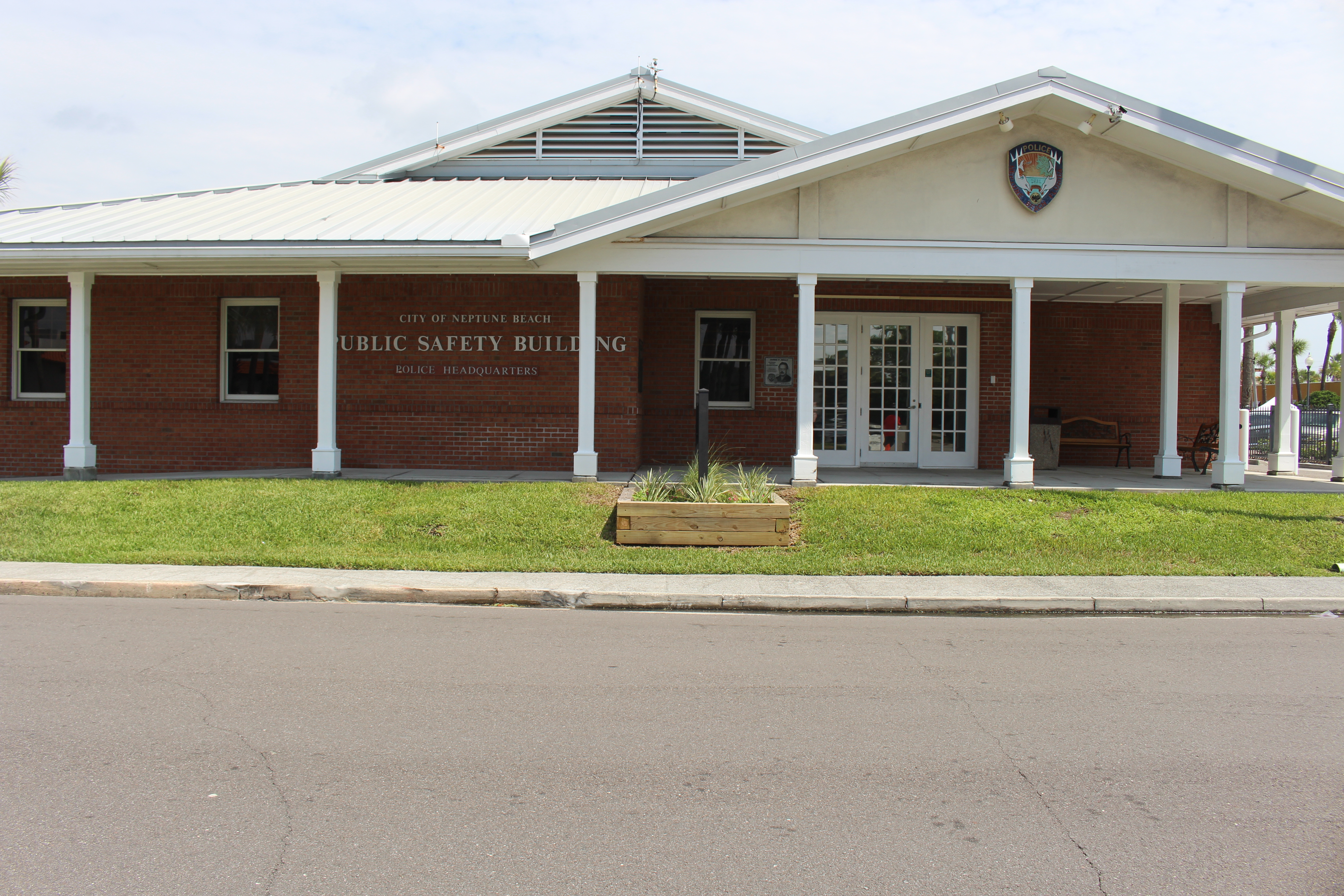 Single-story red brick public safety building with white roof and front columns.