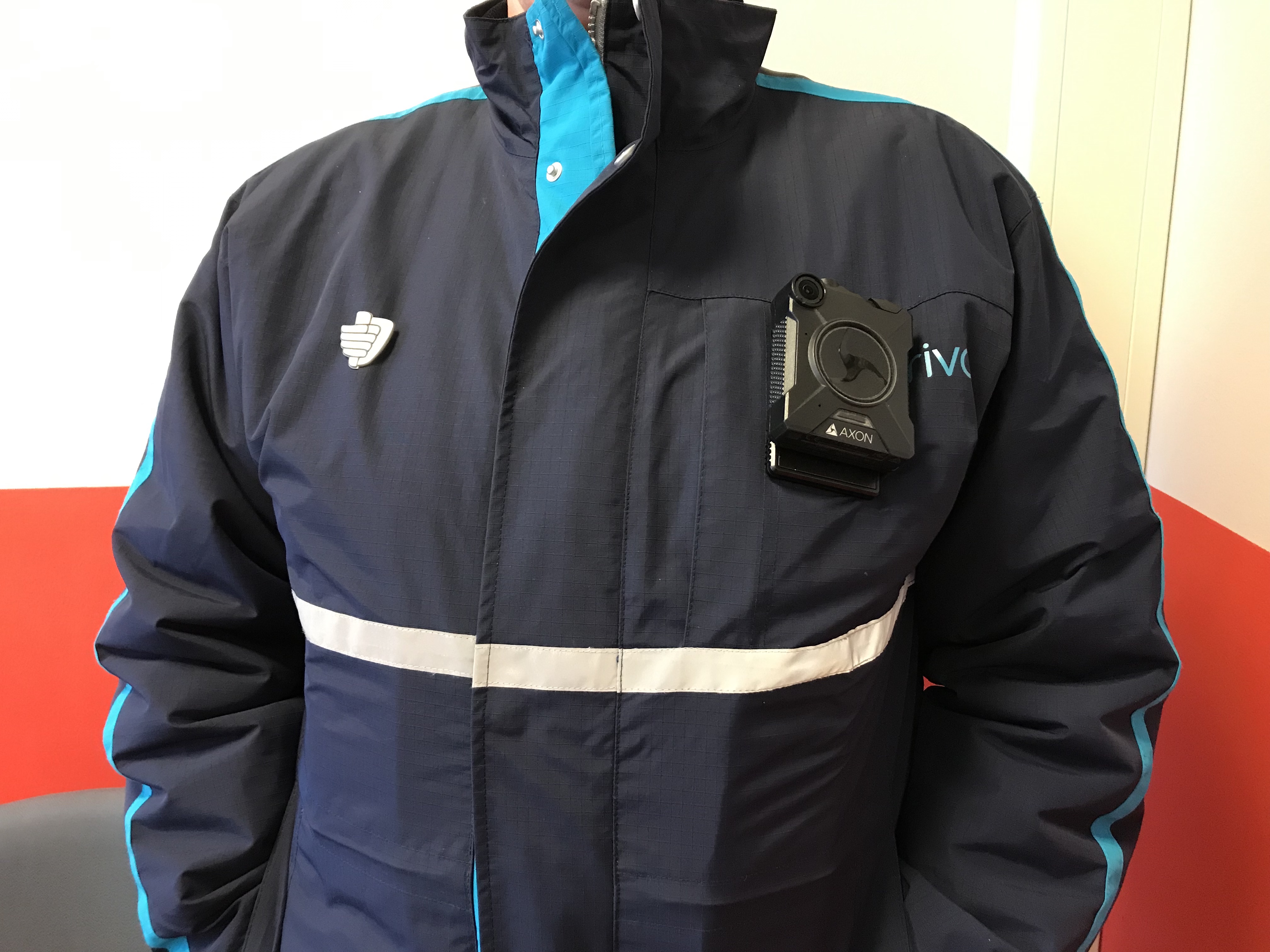 A small body camera clipped to the chest of a dark navy uniform jacket.