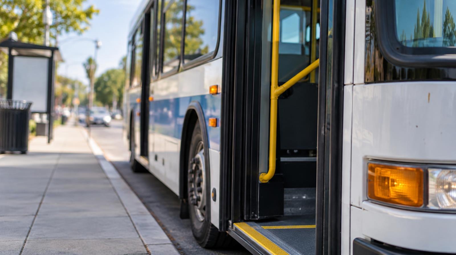 A public transit bus stopped at a curb with its doors open.