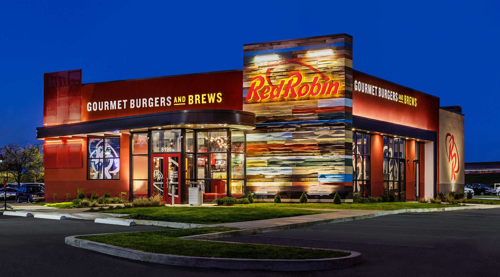Red Robin restaurant exterior at dusk with illuminated red and colorful signage.