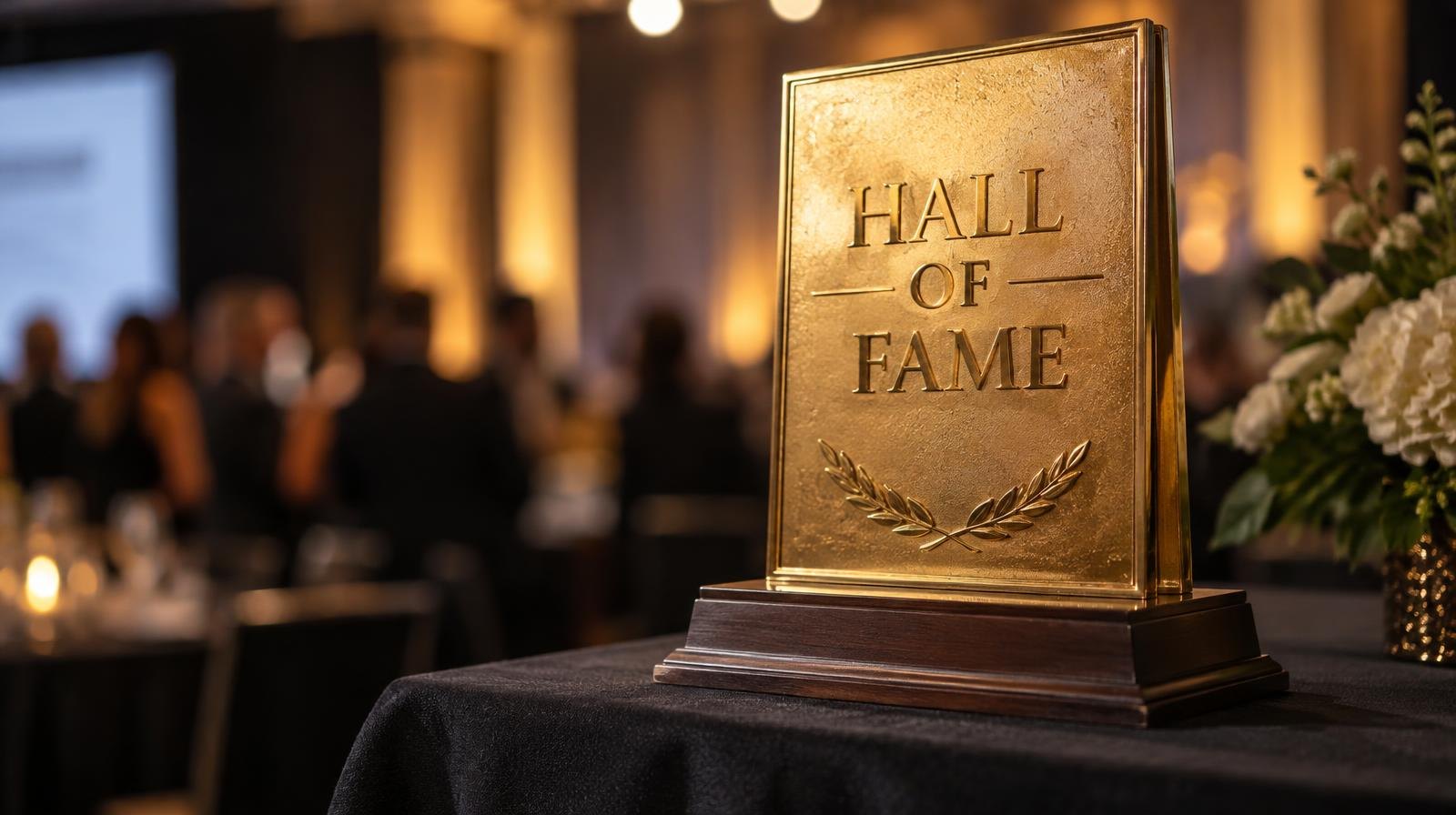 A gold award plaque mounted on a dark wood base on a draped table.