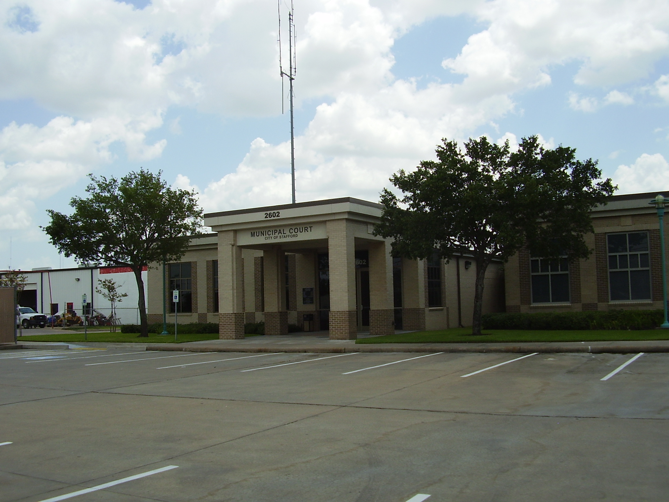 Single-story government building labeled Municipal Court with a columned entrance and parking lot.