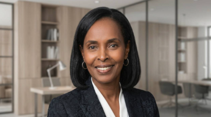 A professional headshot of Dr. Chaunda L. Scott, an Oakland University professor, smiling in a dark blazer with a modern office setting in the background.