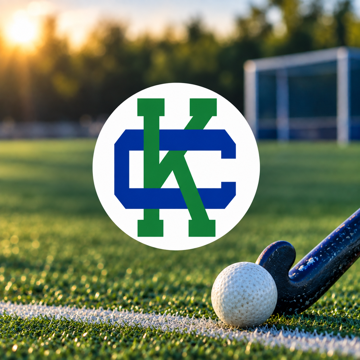 Cranbrook Kingswood field hockey logo over a blurred field hockey field with a stick and ball.