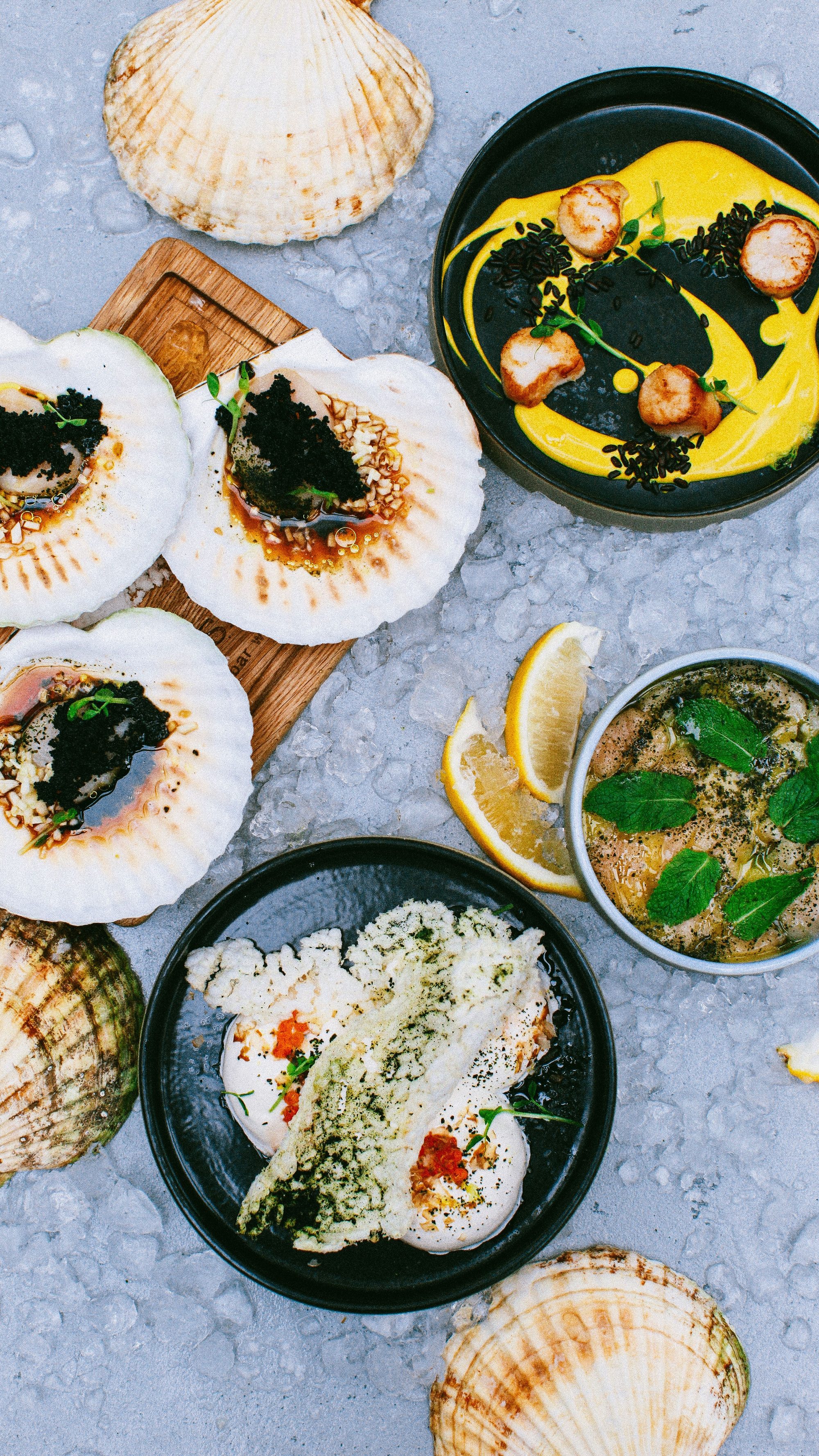 A top view of elegantly plated seafood dishes featuring scallops and caviar, perfect for gourmet dining.