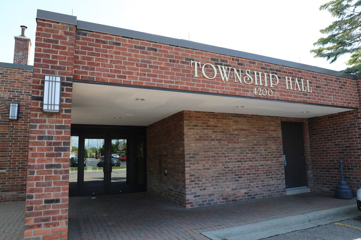Brick municipal building entrance with 'Township Hall 4200' lettering above glass doors.