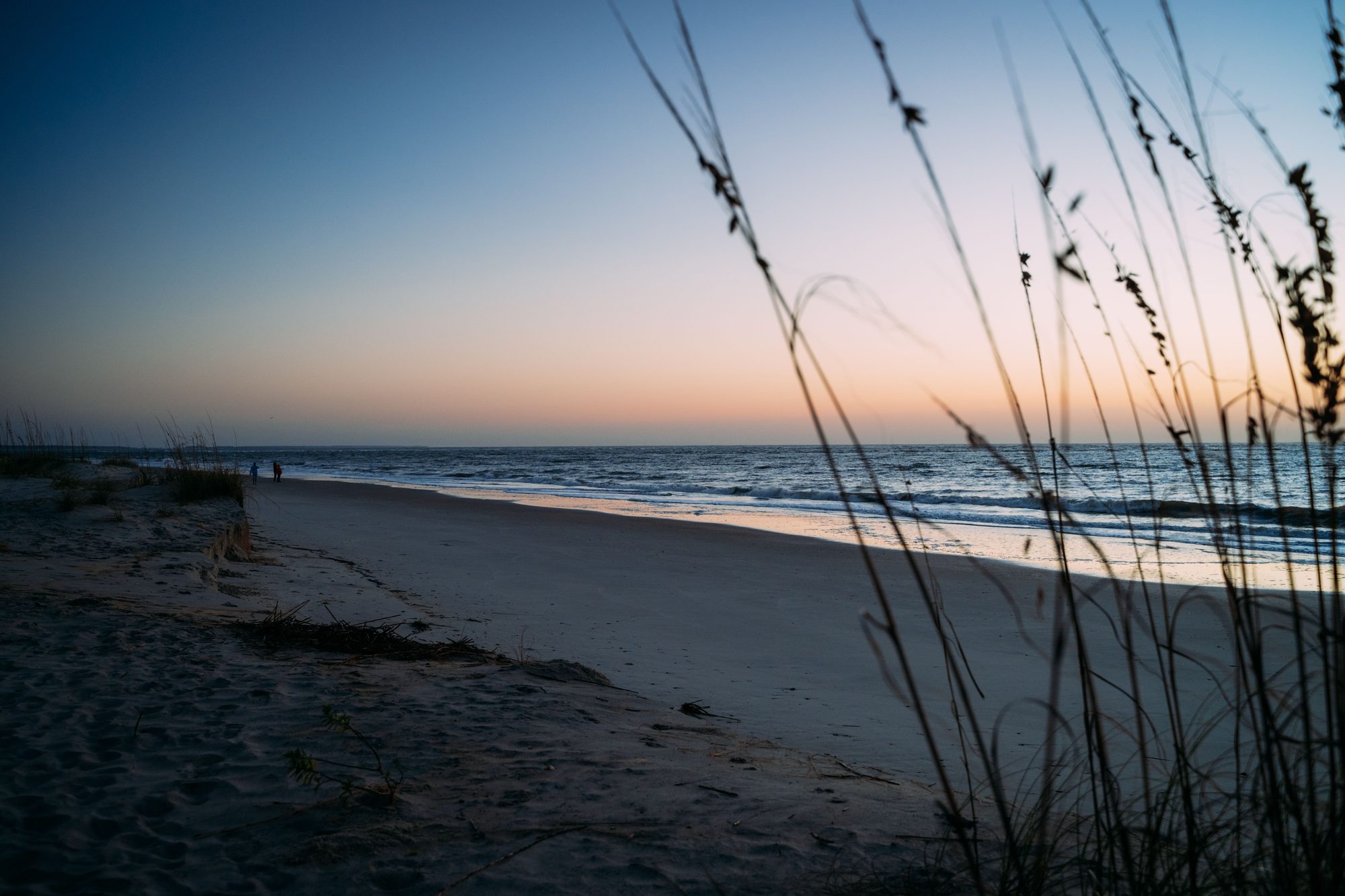 Peaceful beach scene captured at twilight showcasing a serene sunset over the ocean.