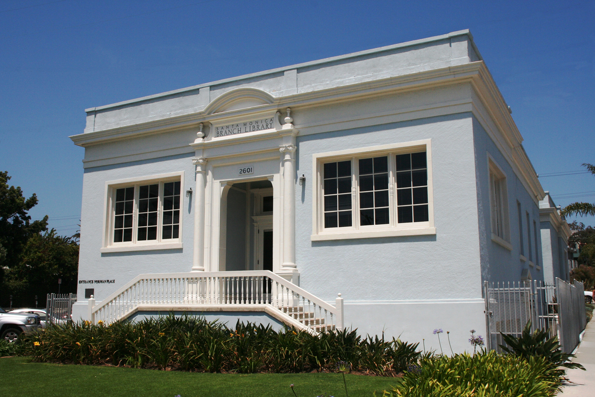 Light blue neoclassical library building with white columns and front entrance steps.
