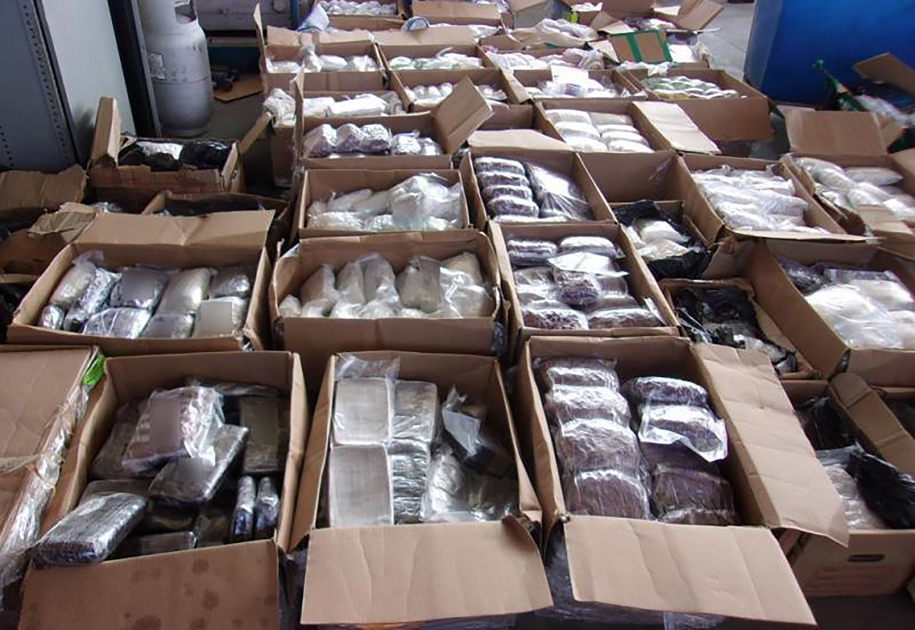 Rows of cardboard boxes filled with plastic-wrapped packages of seized narcotics.