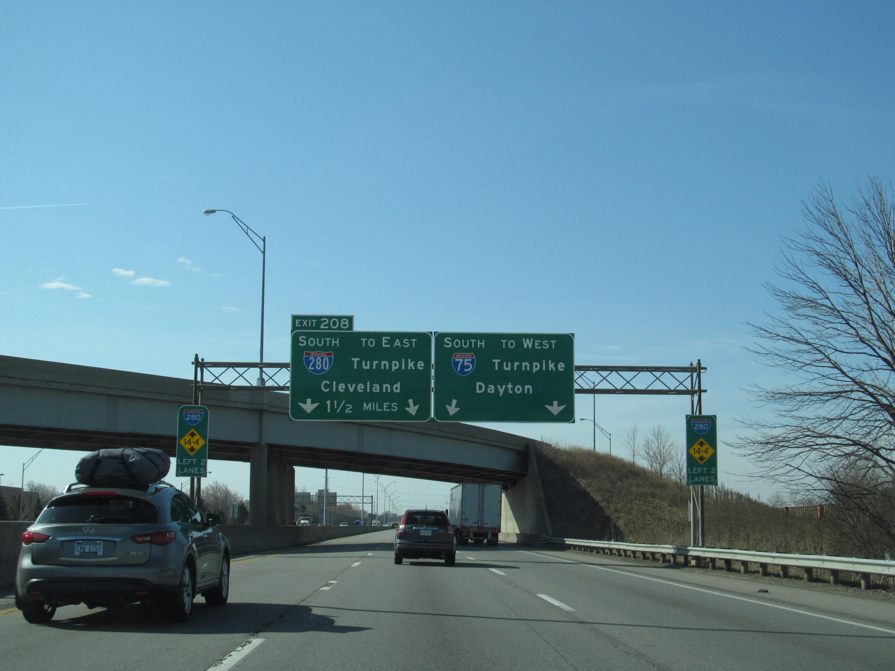 Multi-lane highway with overhead green signs directing traffic toward Dayton on I-75.