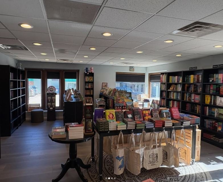 Bookstore interior with wall shelving full of books and a central display table.