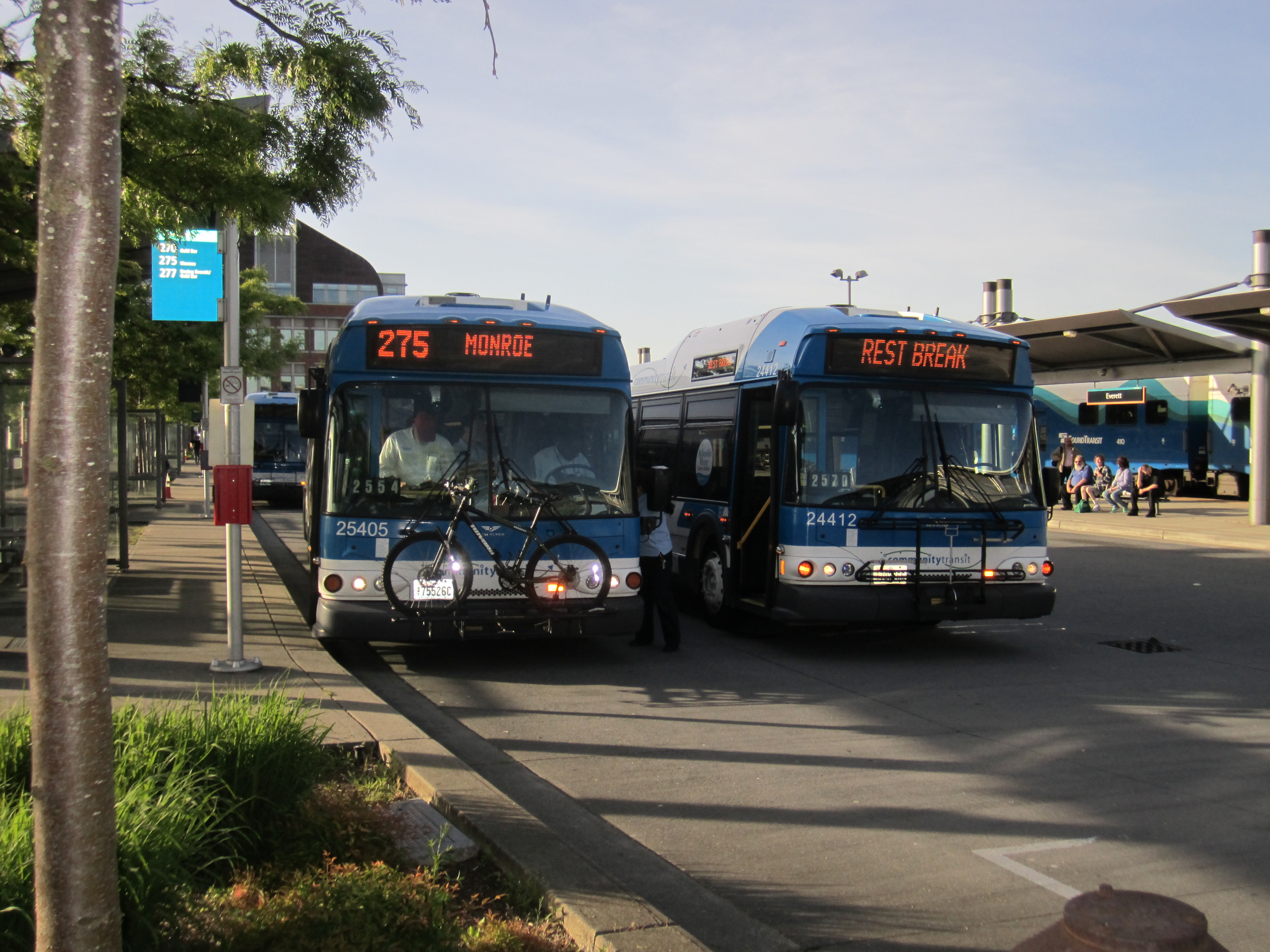 Two blue and white Community Transit buses parked at a transit station.