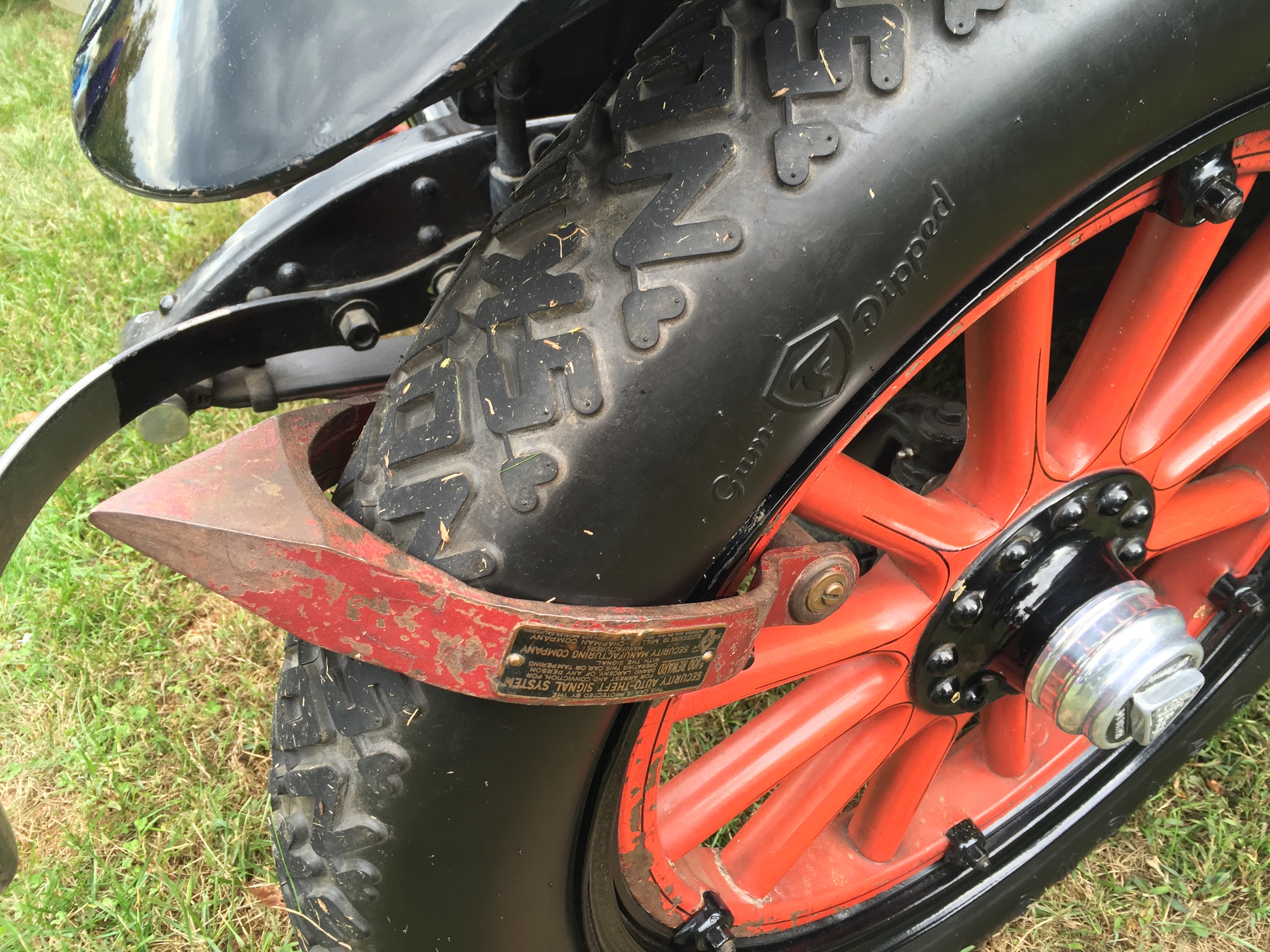 Close-up of a red spoked wheel and fender on a vintage antique automobile.