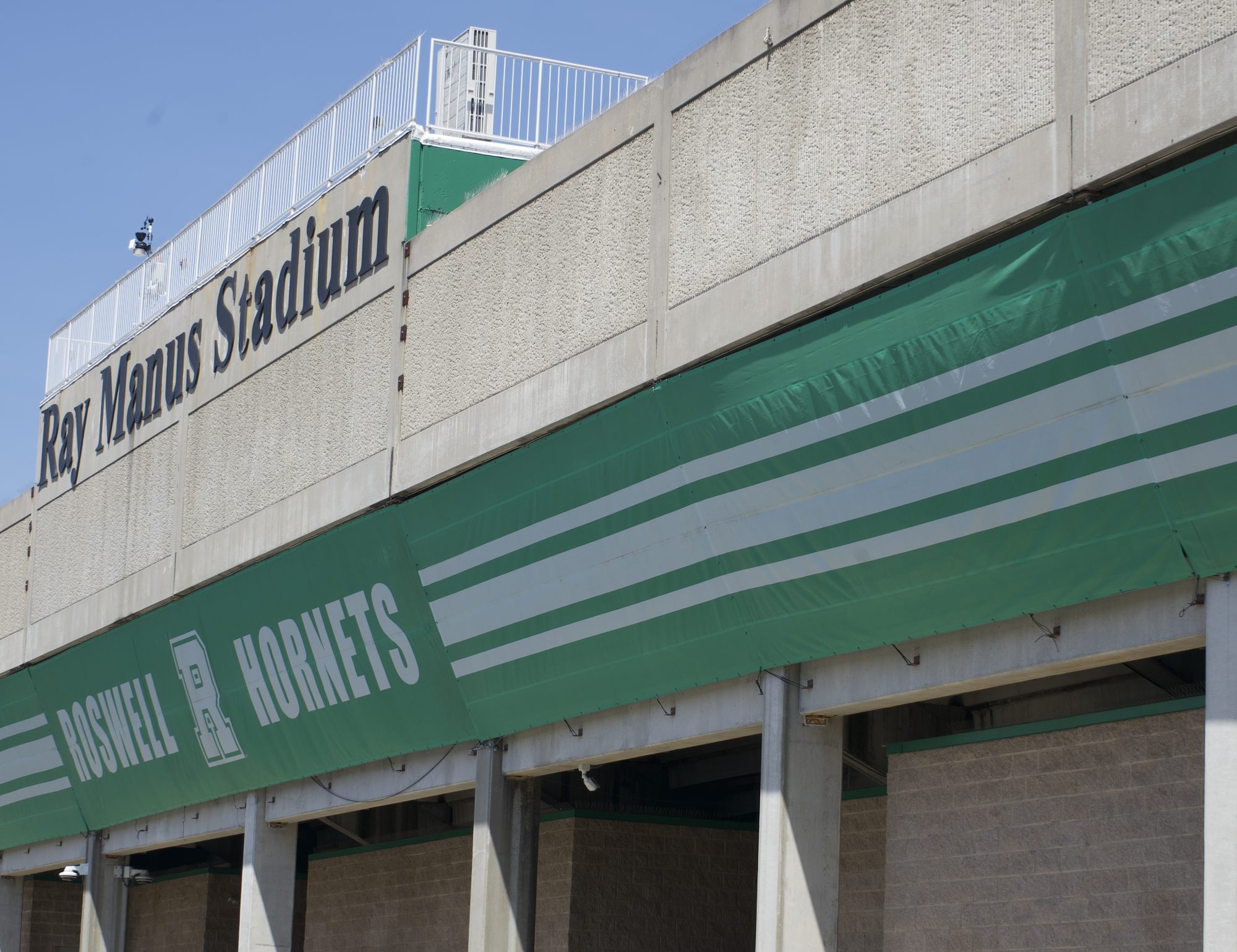 Stadium exterior with green and white Hornets banners on a clear day.