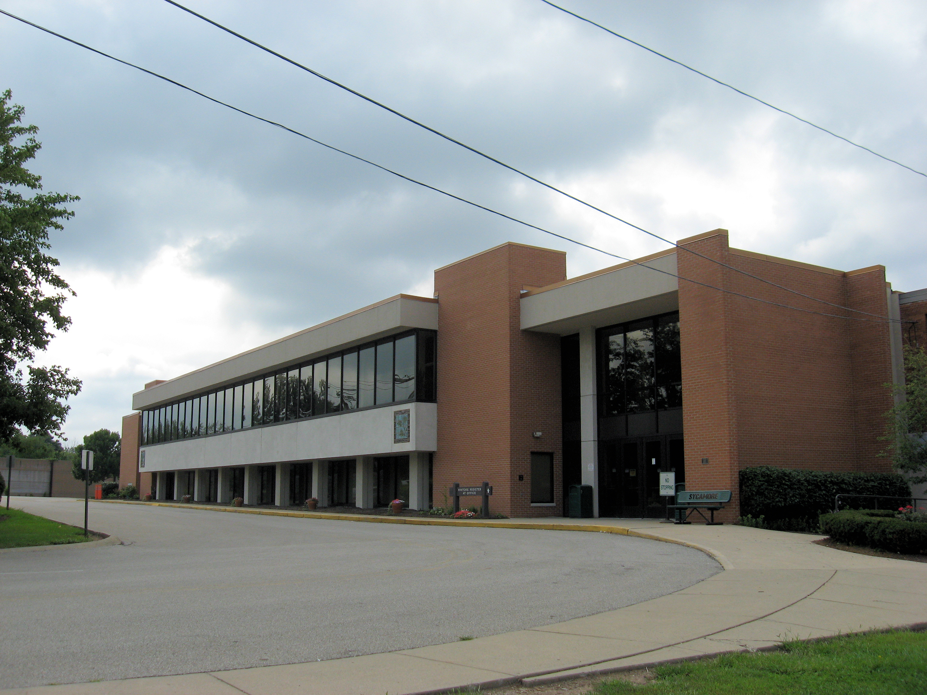 Two-story brick school building with large windows and a covered entrance.