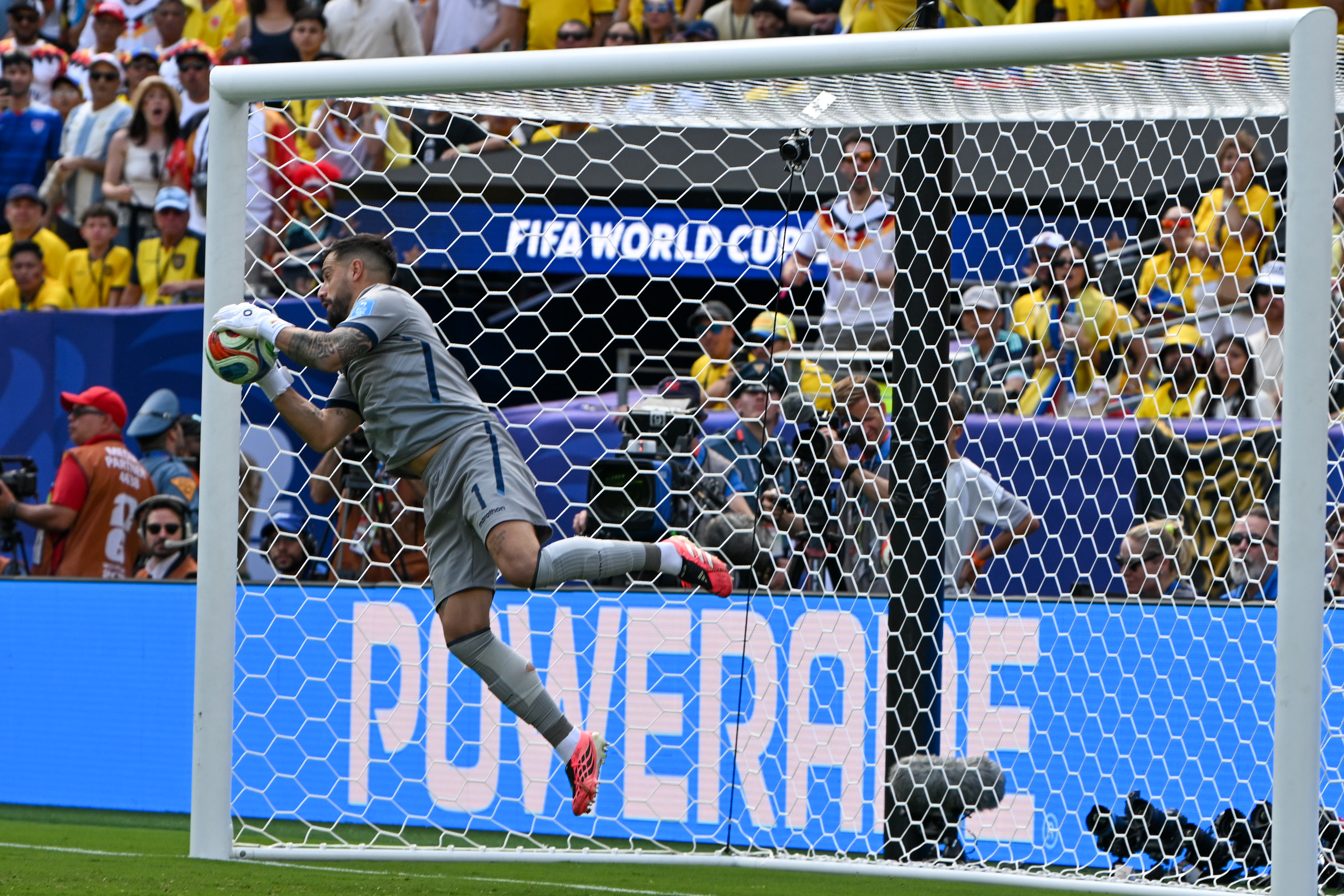 A goalkeeper leaps to make a save inside the goal net at a FIFA World Cup 2026 match.