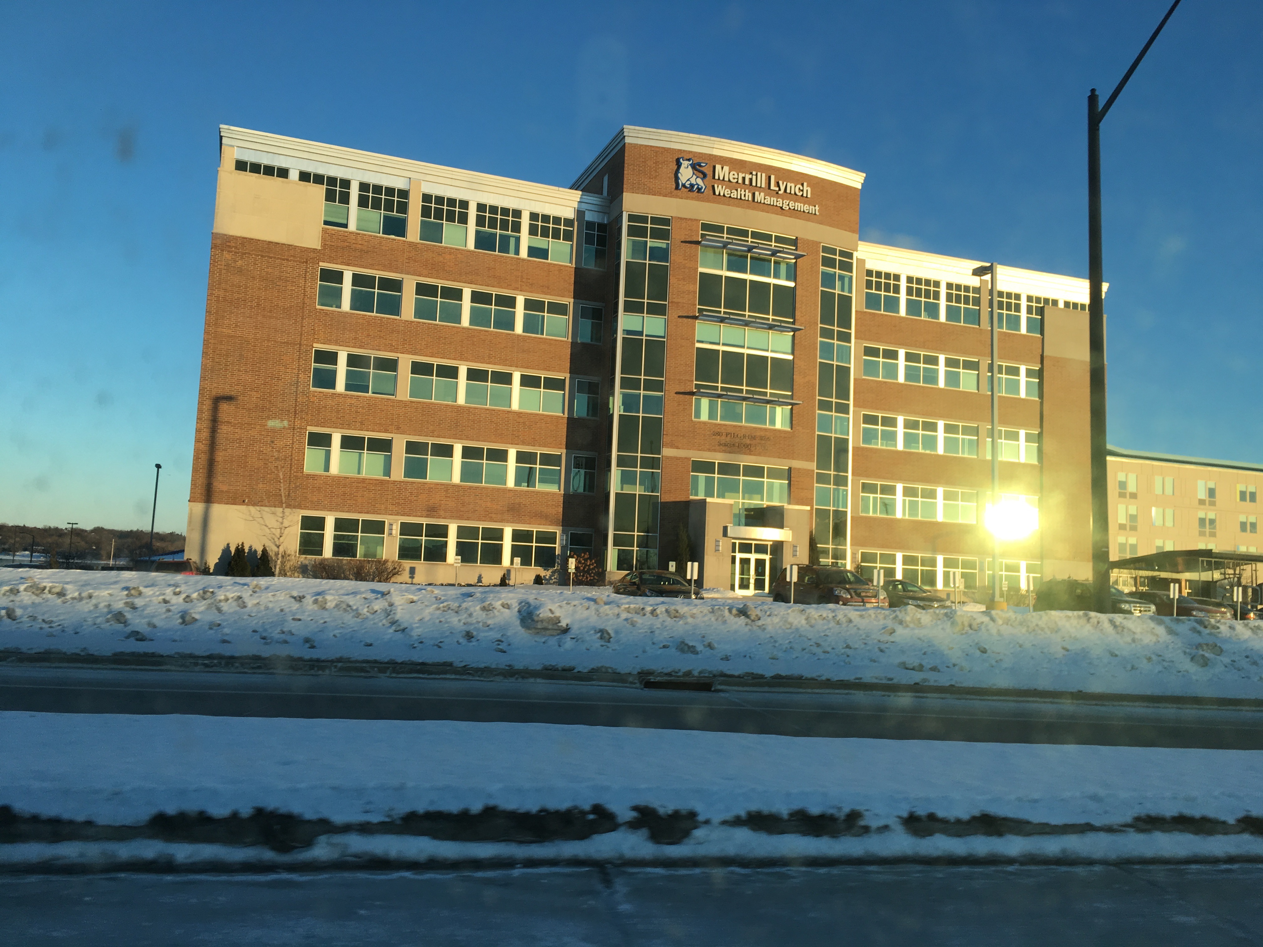 Brick office building with a Merrill Lynch Wealth Management sign near the entrance.