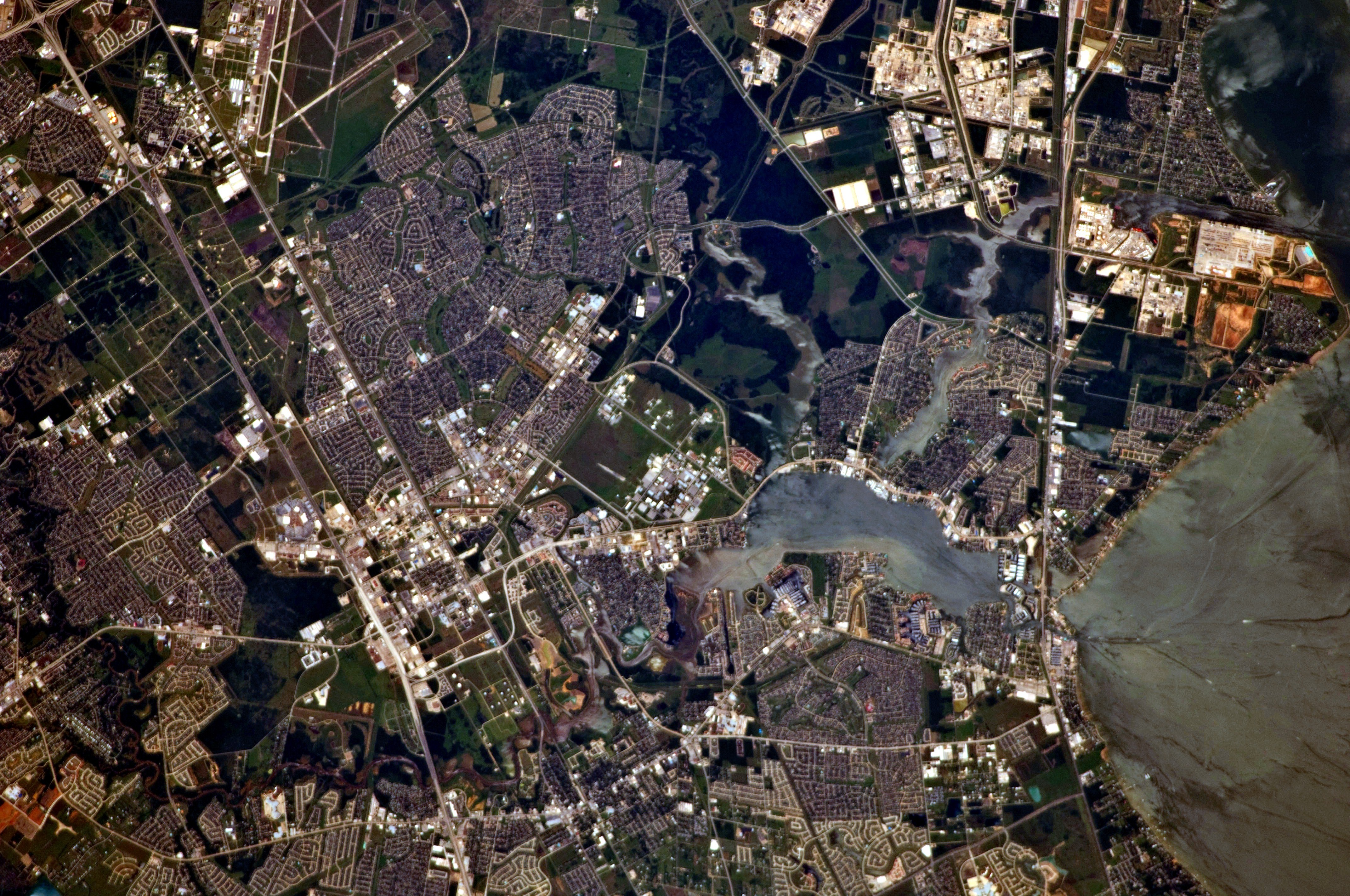 Aerial view of NASA Johnson Space Center campus and Clear Lake from orbit.