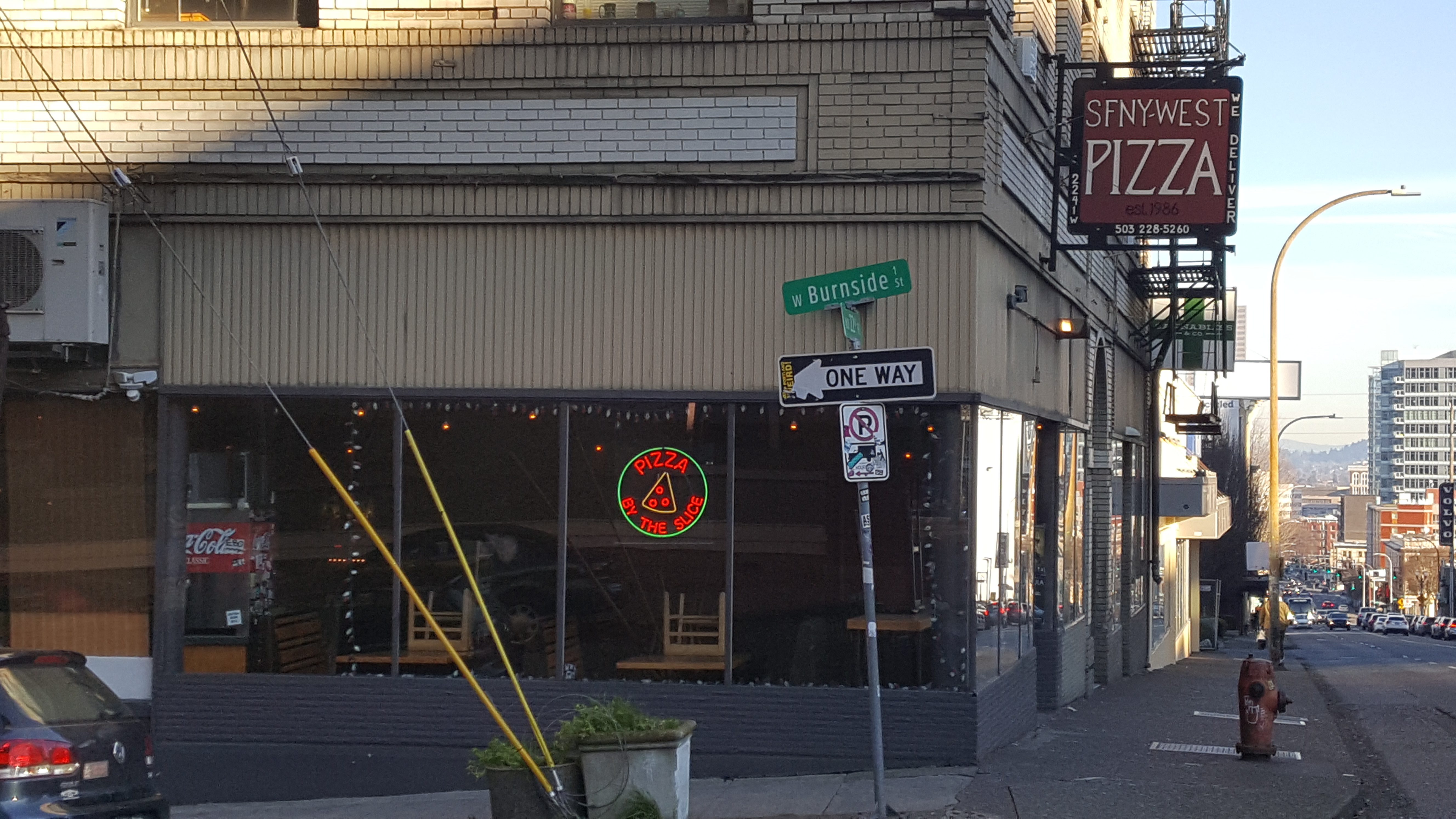 Street corner with a green Burnside Street sign and storefront in Northwest Portland.