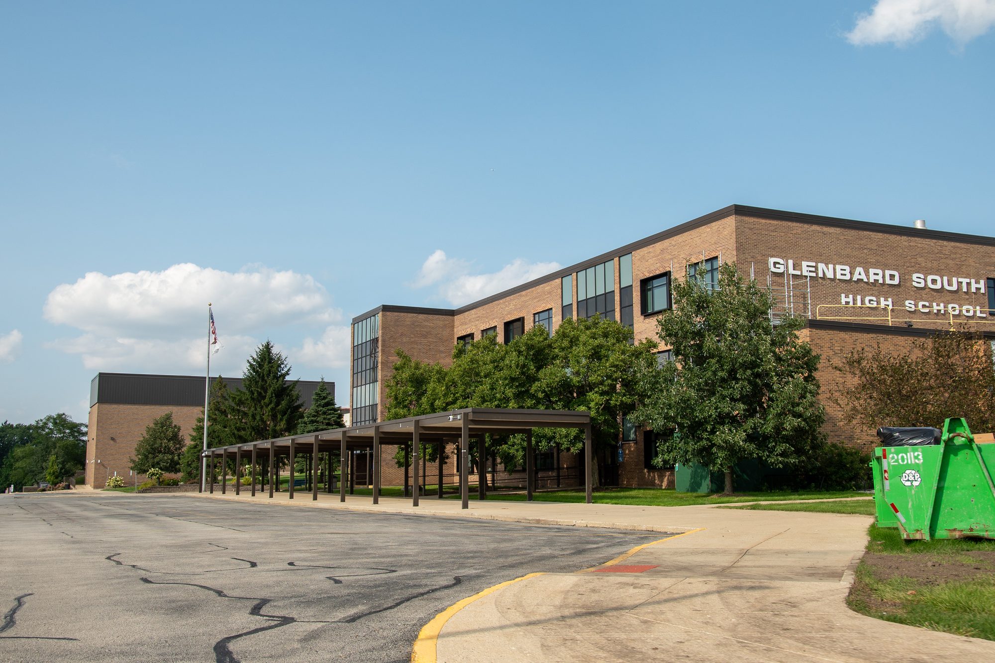 Exterior of a multi-story brick high school building on a sunny day.