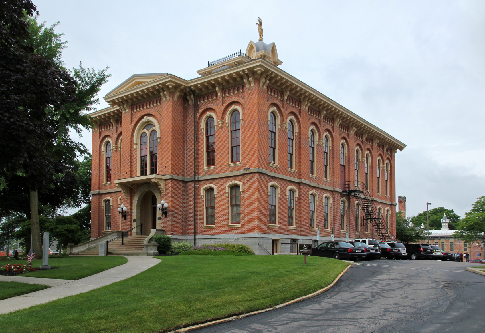 Red brick Italianate courthouse with arched windows and a gold-topped cupola.