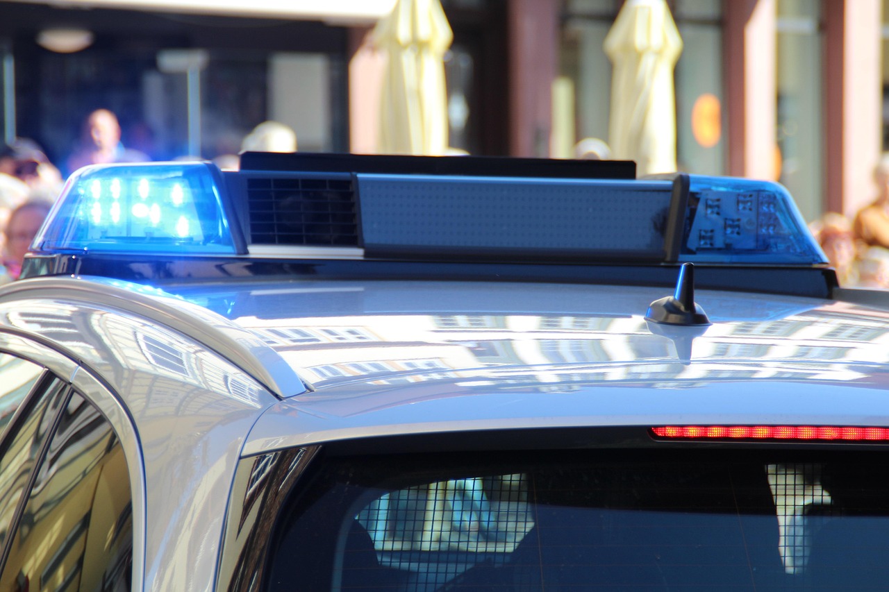 Close-up of a police car's activated blue emergency lights on its roof-mounted light bar.