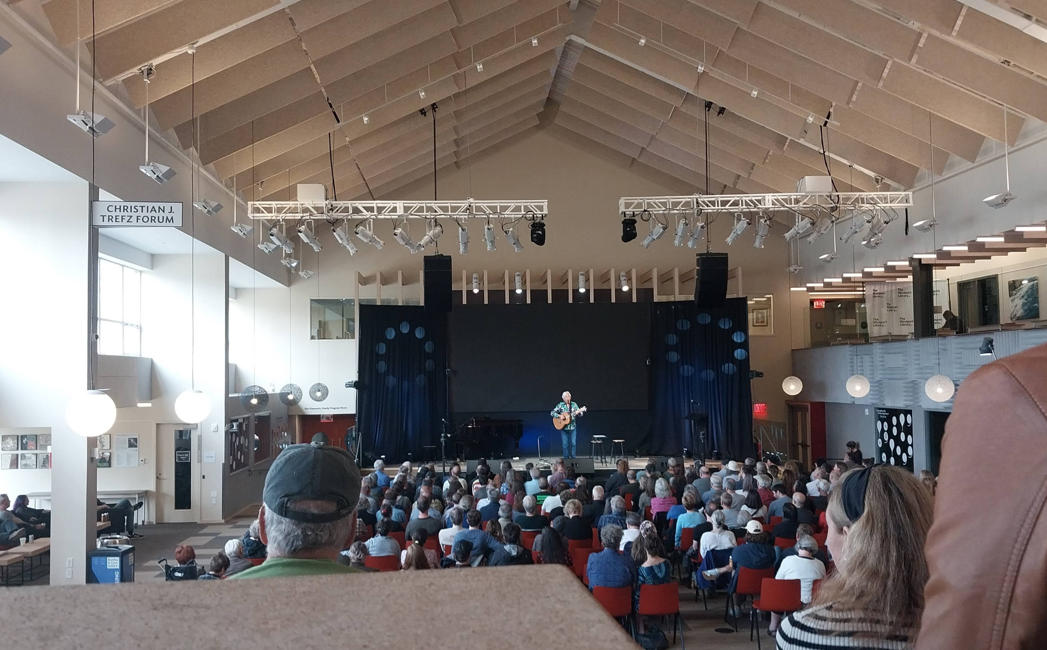 A stage and filled auditorium inside the Westport Public Library.