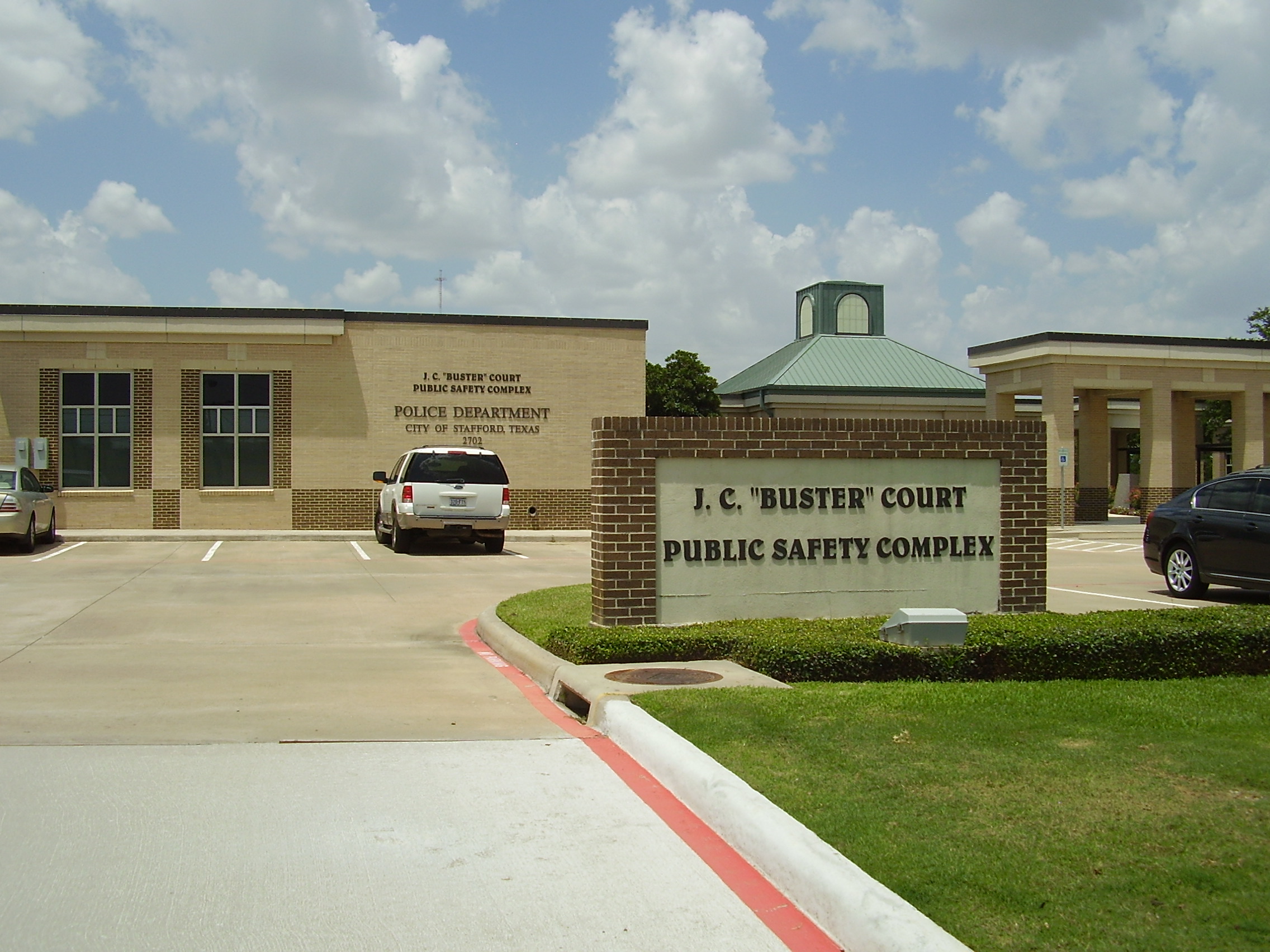 Exterior of a brick police department building with a monument sign in the foreground.