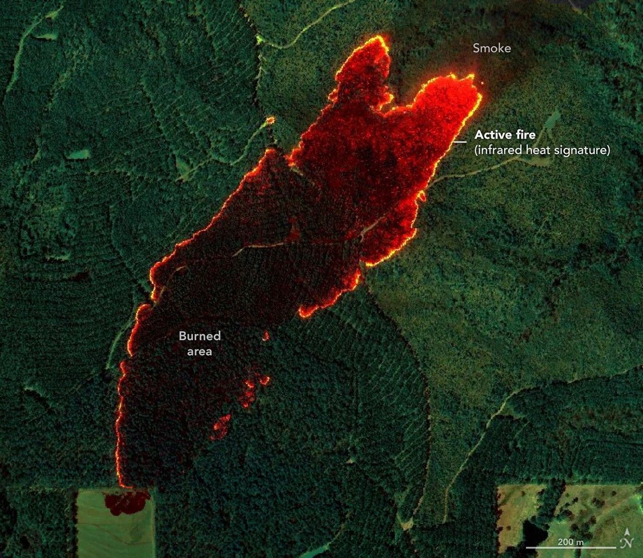 Aerial infrared view of a wildfire showing orange flames, dark burned area, and rising smoke.