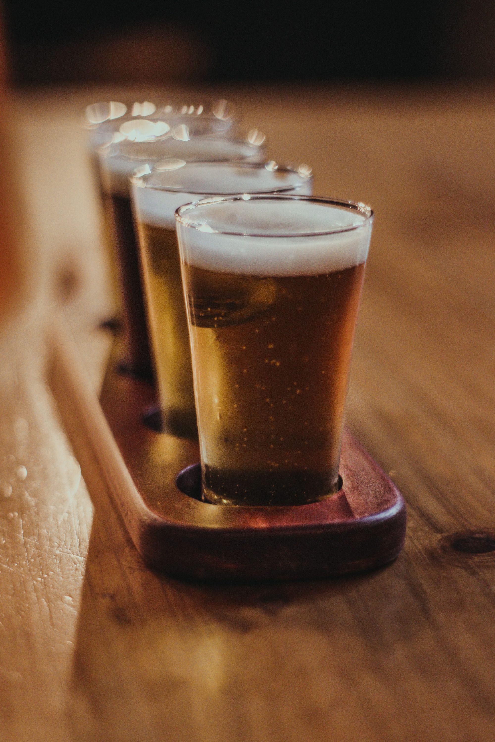 Close-up of craft beer flight on wooden table, showcasing assorted beers in Provincia de Lima, Perú.