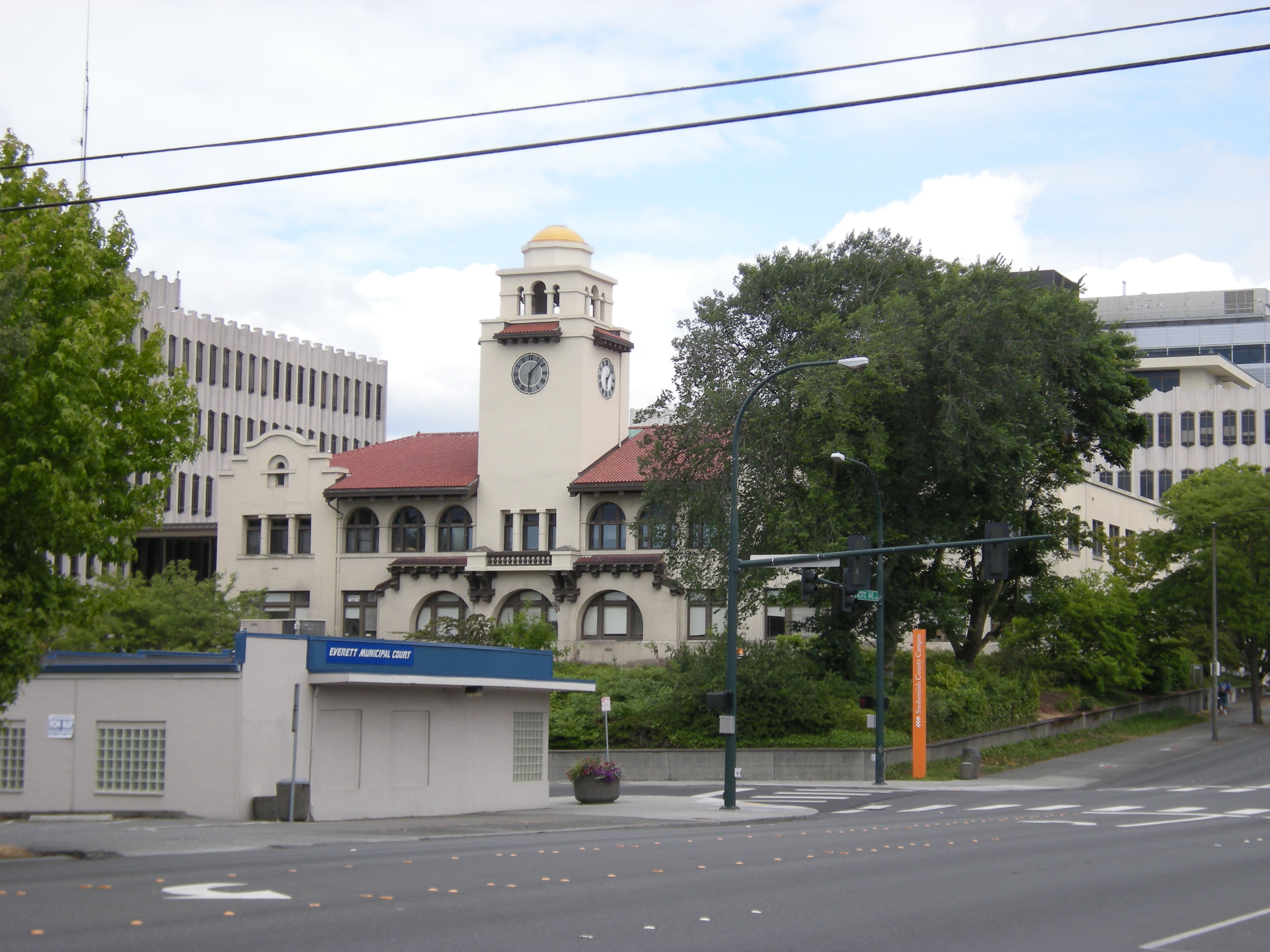 Historic Mission Revival courthouse with a clock tower at a street intersection.