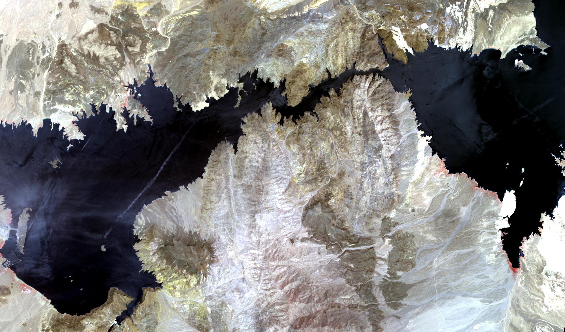 Satellite image of a reservoir with a wide pale ring of exposed shoreline around its edges.