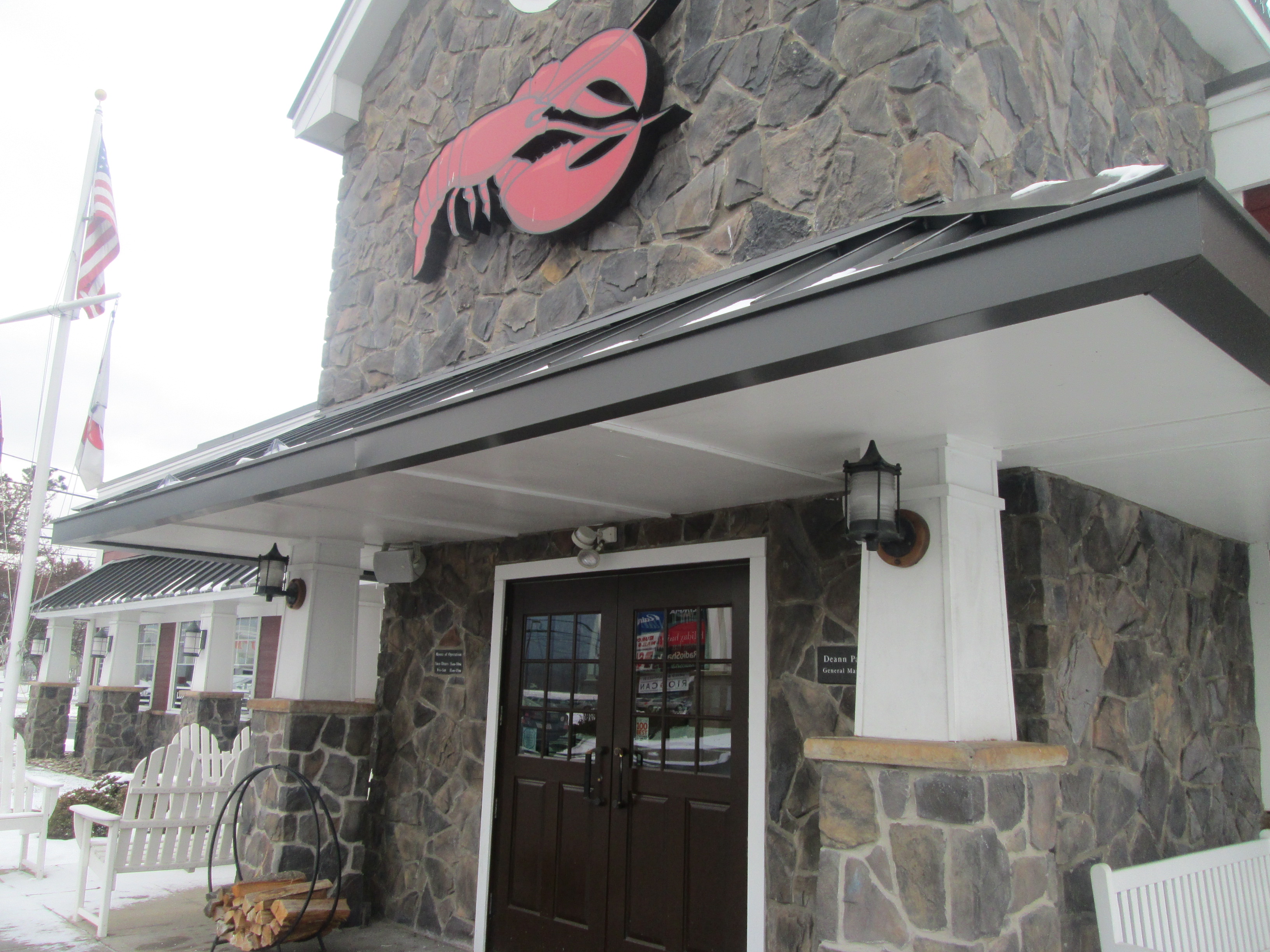Stone facade entrance of a Red Lobster restaurant with lobster logo sign above the doors.