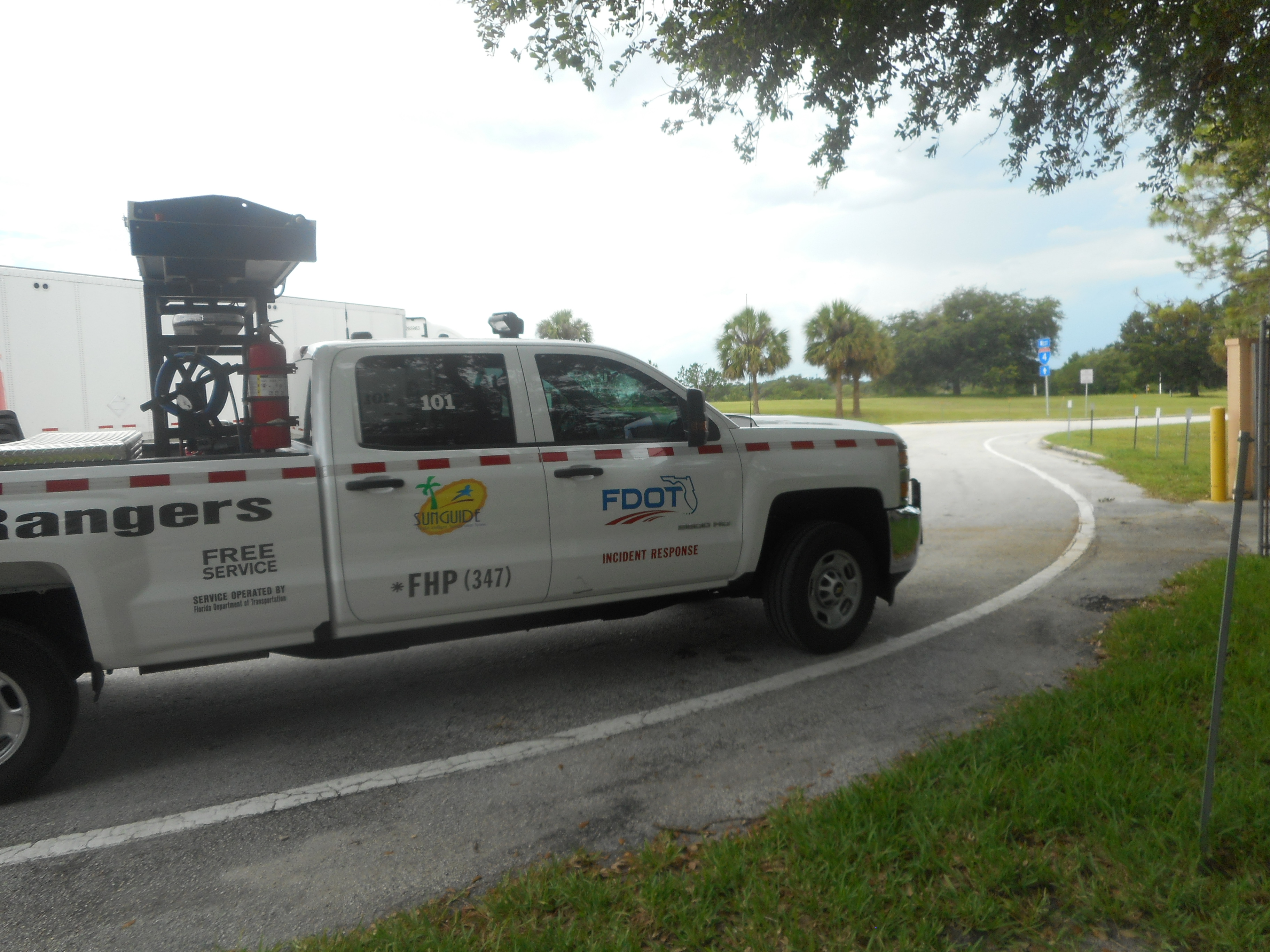 White FDOT Road Ranger pickup truck with agency markings parked at a rest area.
