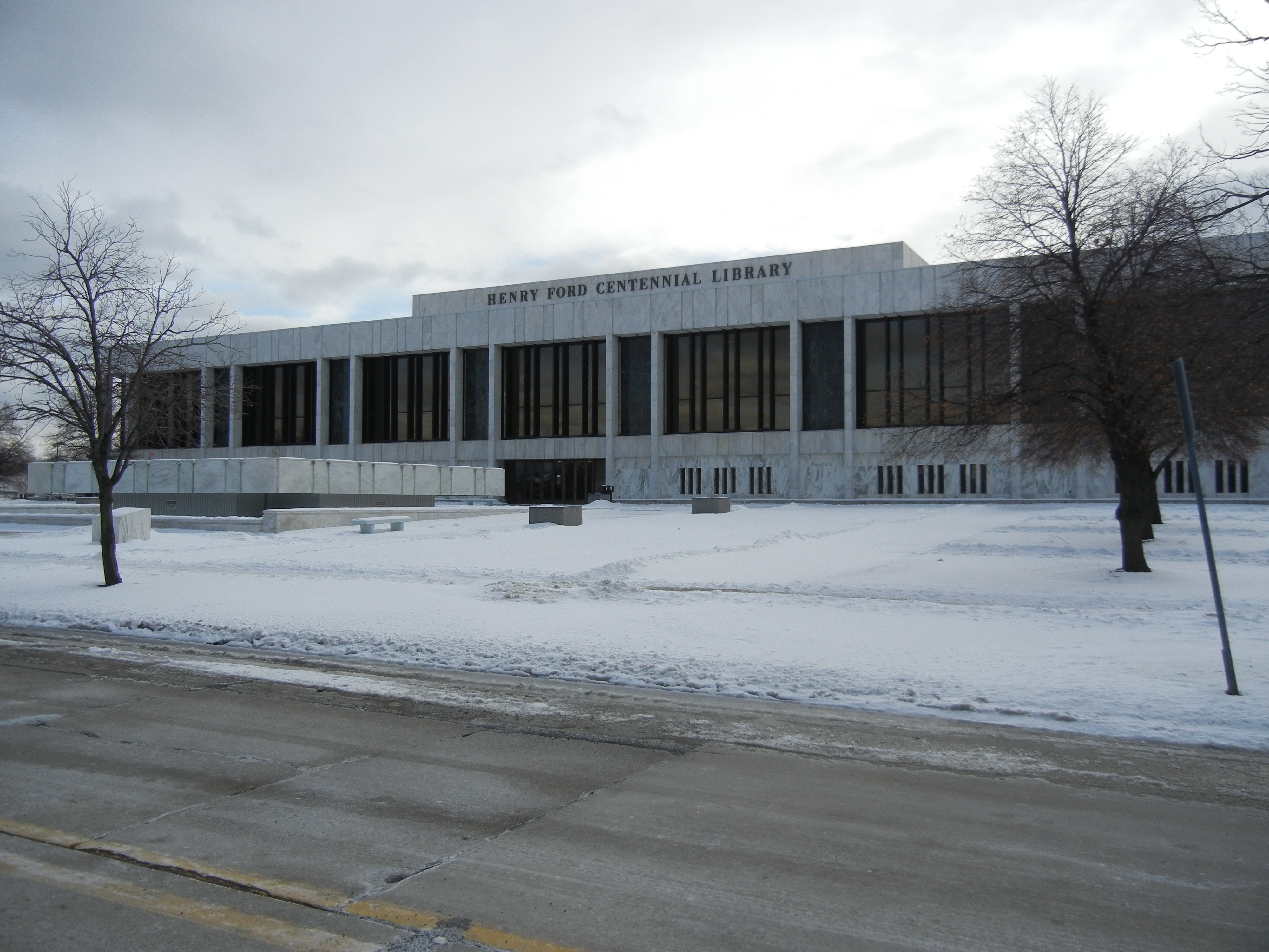 Large modernist library building with snow on the ground and bare winter trees.